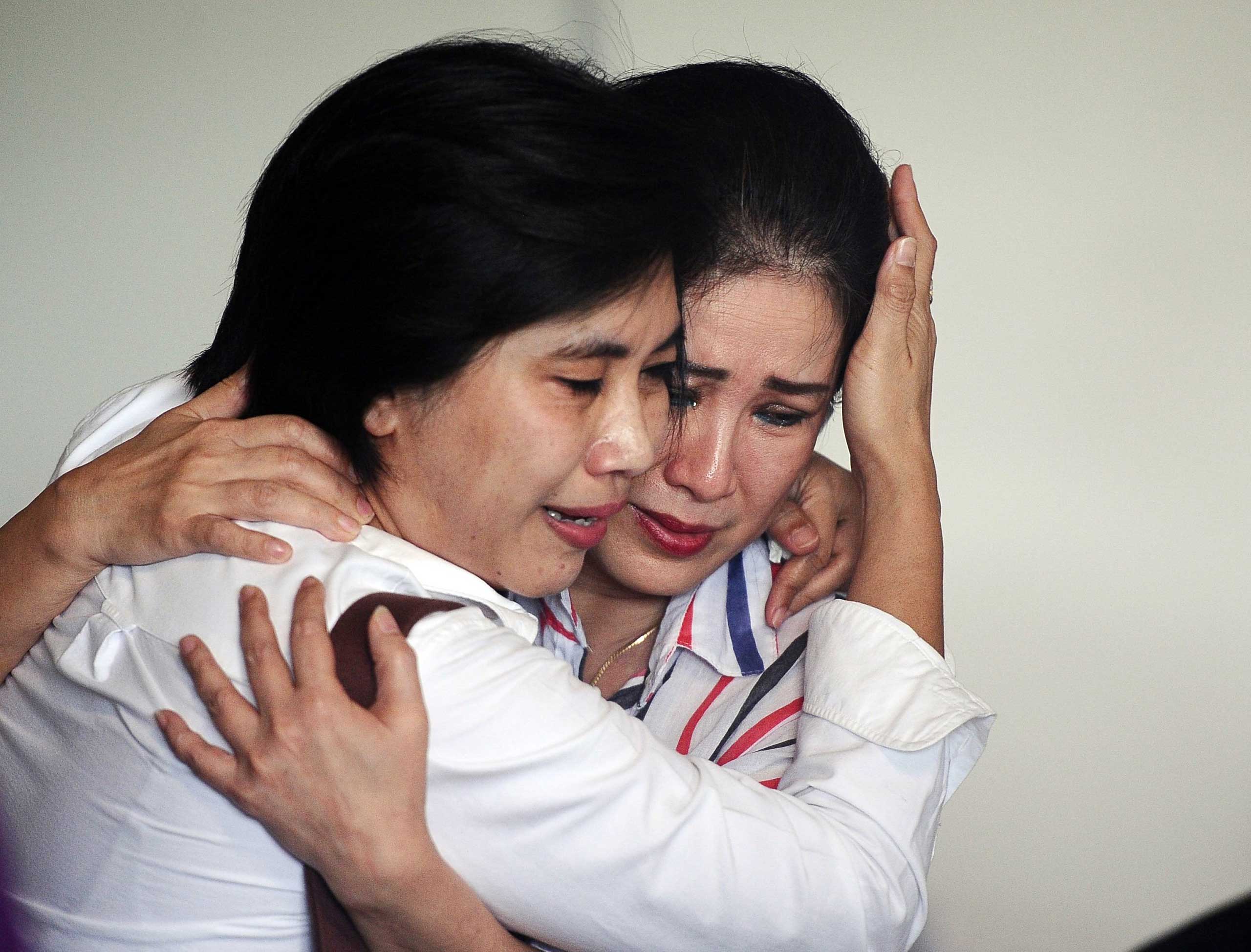 Relatives of passengers on AirAsia flight QZ 8501 react to the news of debris and bodies being found, in Surabaya, Indonesia on Dec. 30, 2014.