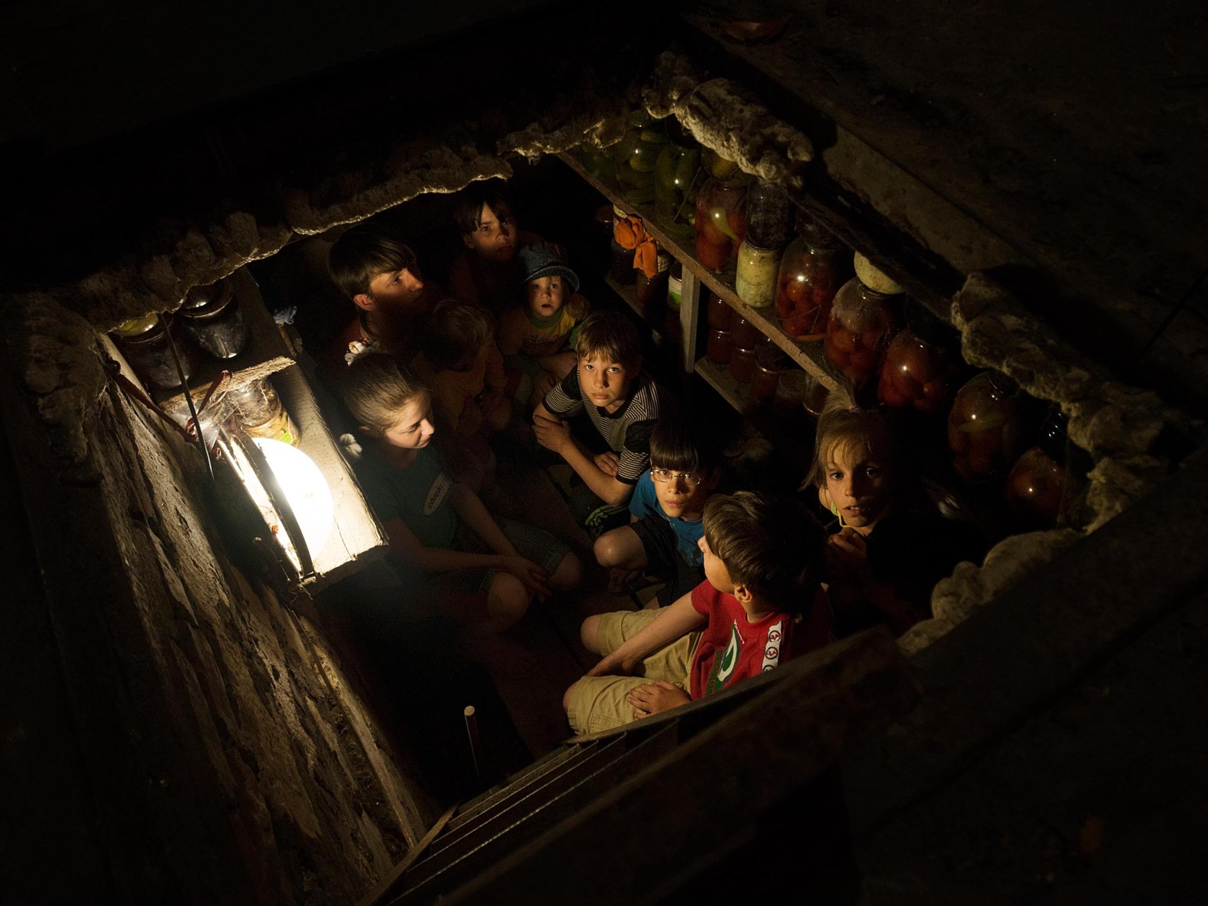 A family gives shelter to 10 orphans seeking refuge from overnight bombing in their basement in Slovyansk, Ukraine, on May 14, 2014.