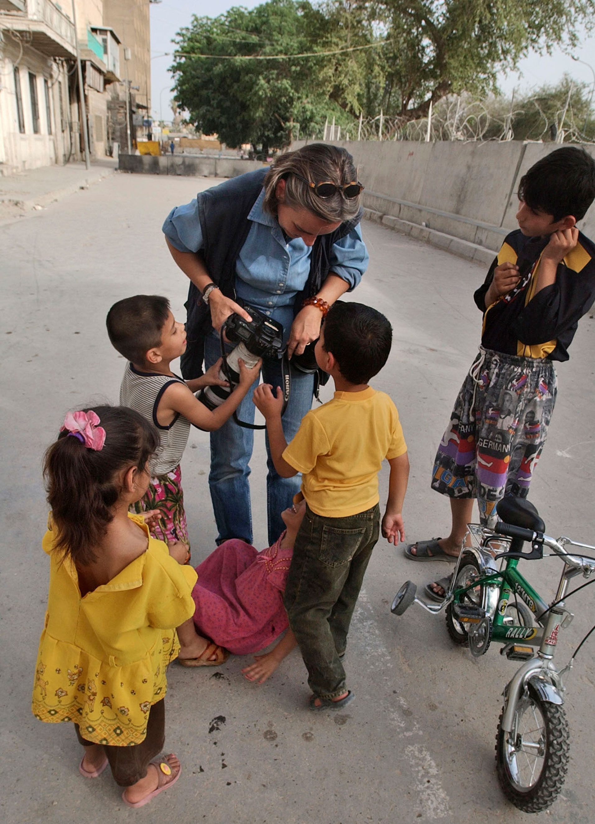 Anja Niedringhaus shows Iraqi children their pictures in Baghdad in 2004.