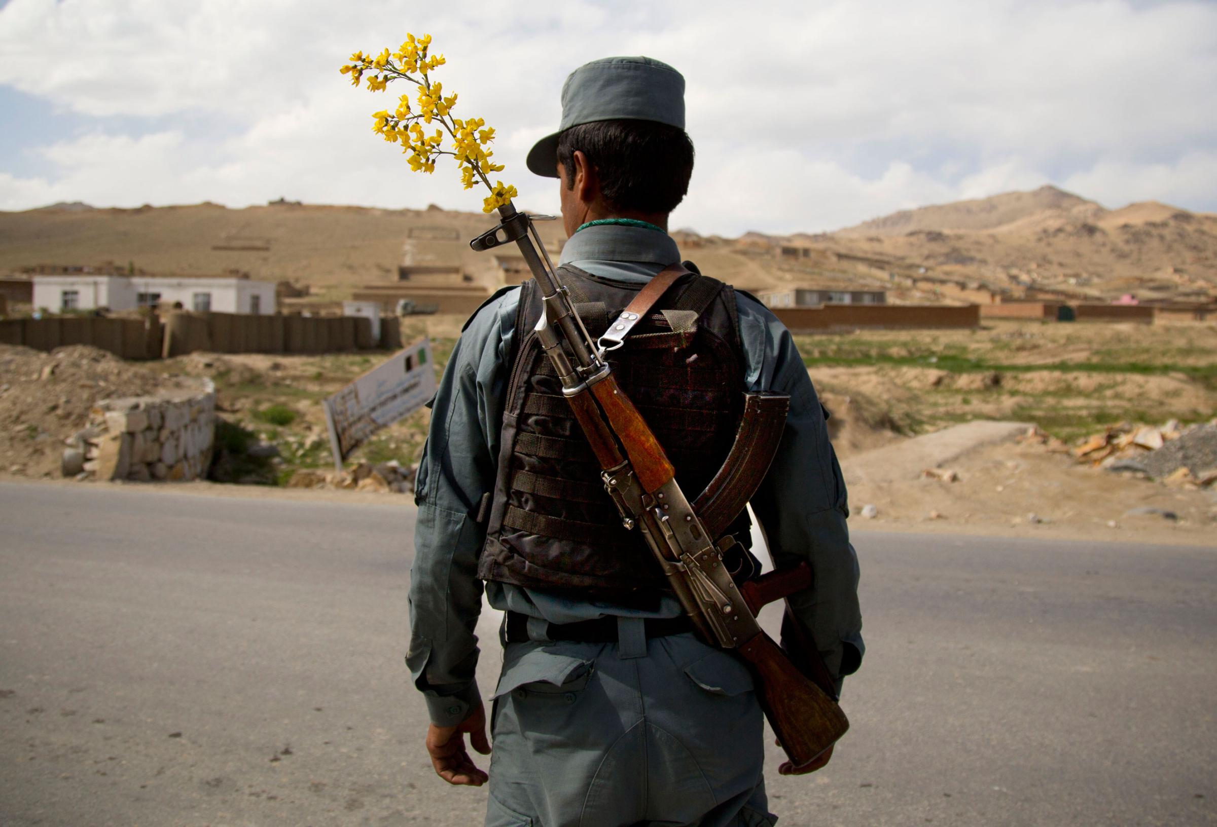 An Afghan National Police officer mans a checkpoint on the outskirts of Maidan Shahr, Wardak province, on May 15, 2013.