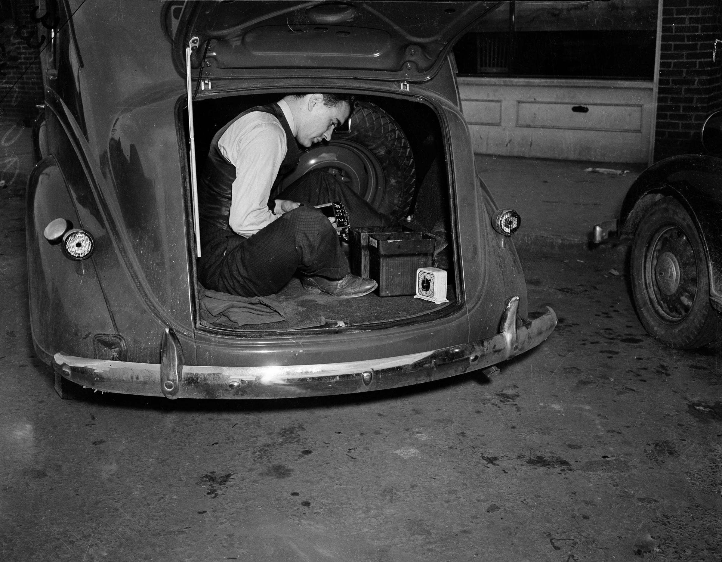 Photographer Bill Allen uses the trunk of his car as a darkroom to develop film coverage of a 1938 Virginia mine explosion.
