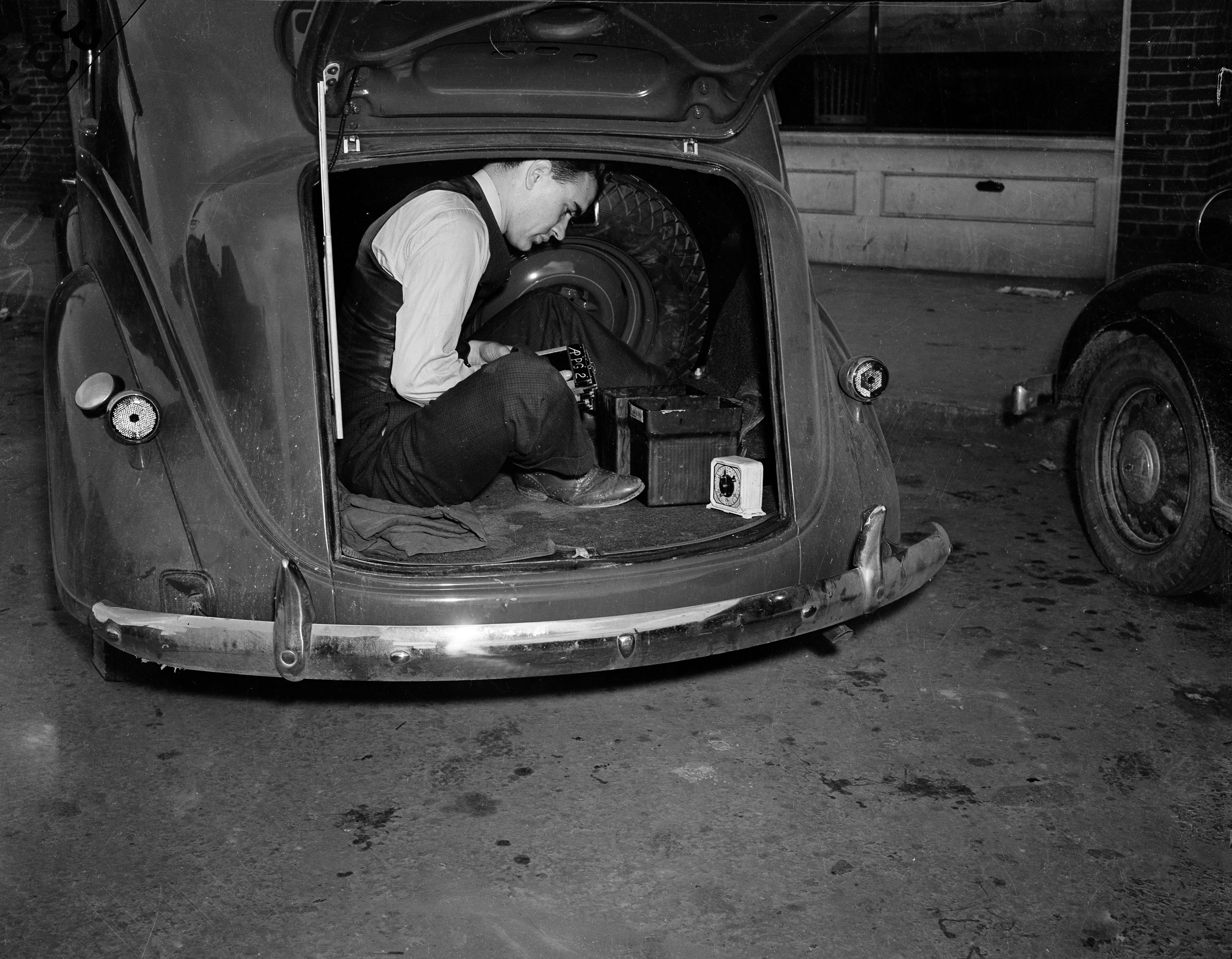 Photographer Bill Allen uses the trunk of his car as a darkroom to develop film coverage of a 1938 Virginia mine explosion. (Associated Press Corporate Archives)
