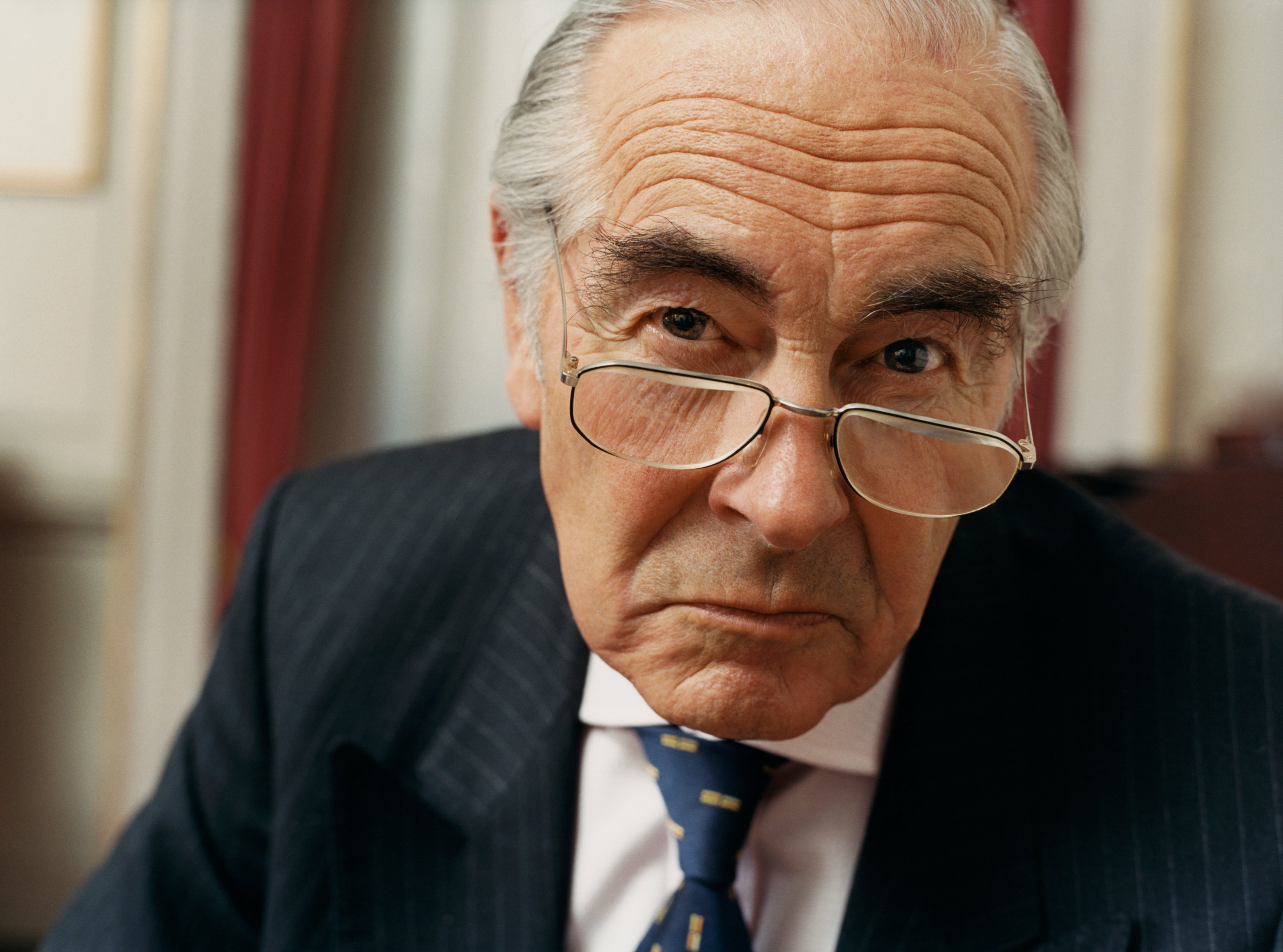 Portrait of a Sulking Businessman Wearing Spectacles and a Pinstripe Suit (Digital Vision.&mdash;Getty Images)