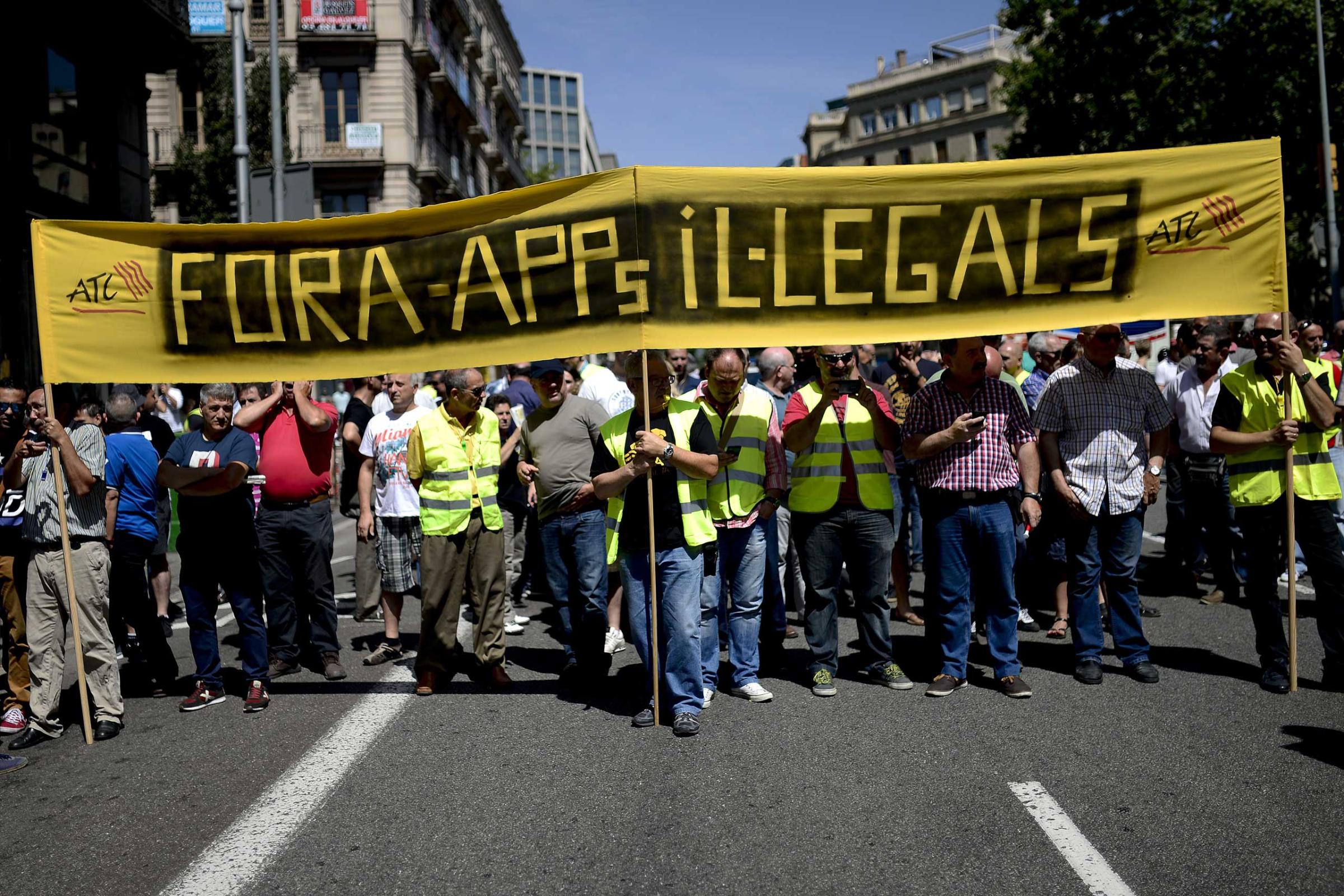 Taxi drivers hold a banner during a protest in Barcelona on June 11, 2014.
