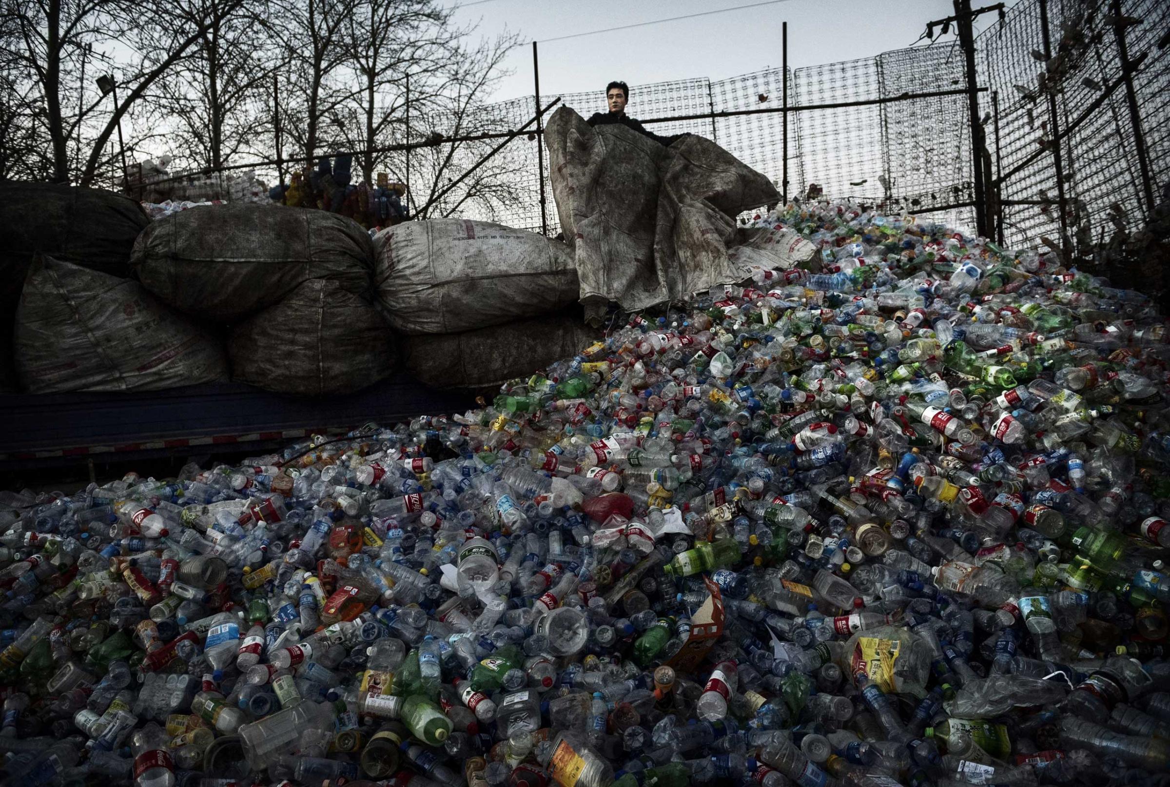 A laborer unloads plastic bottles to be recycled in the Dong Xiao Kou village on Dec. 12, 2014 in Beijing.