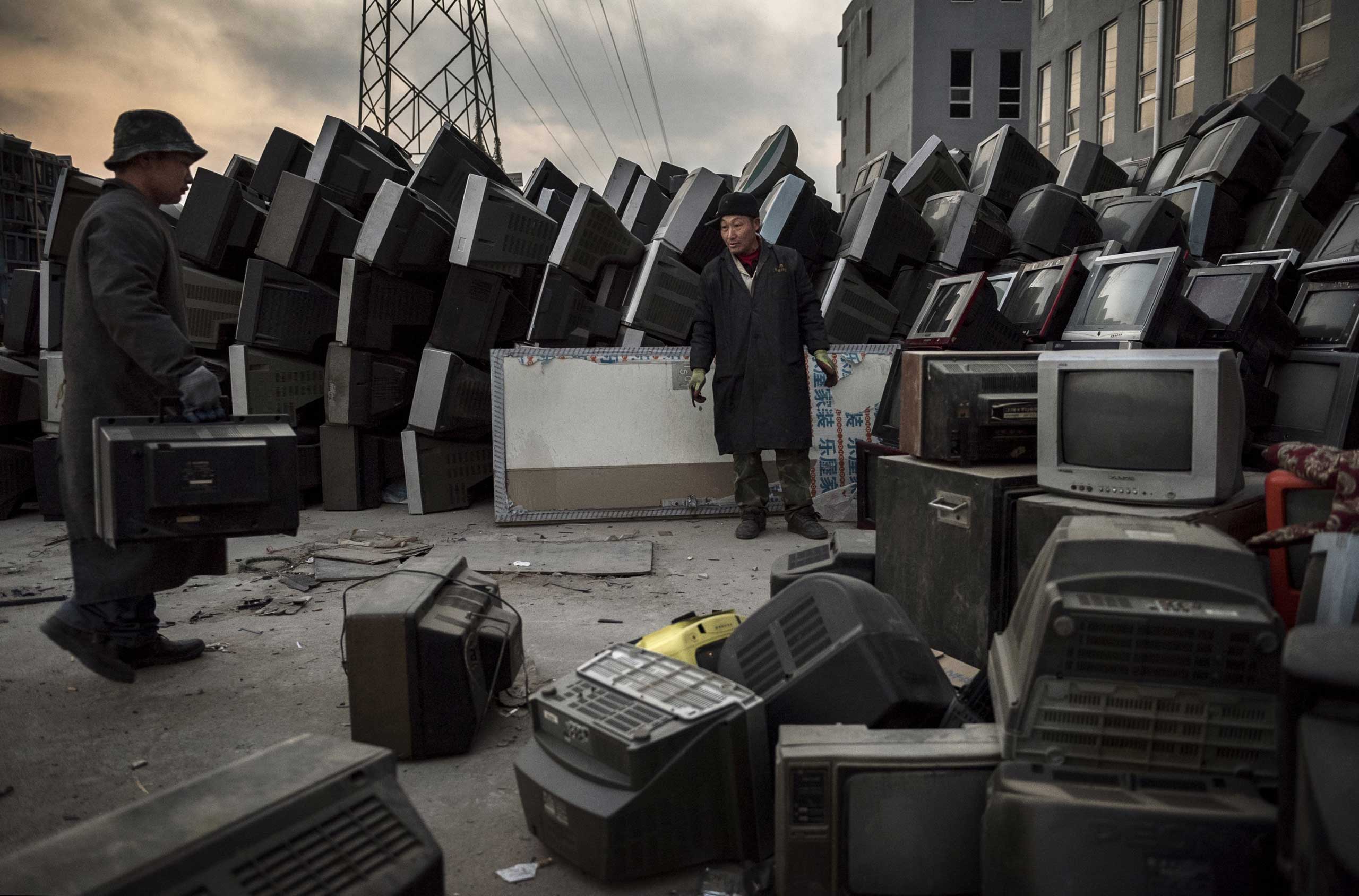 Laborers organize old televisions and computers to be recycled in the Dong Xiao Kou village on Dec. 11, 2014 in Beijing.
