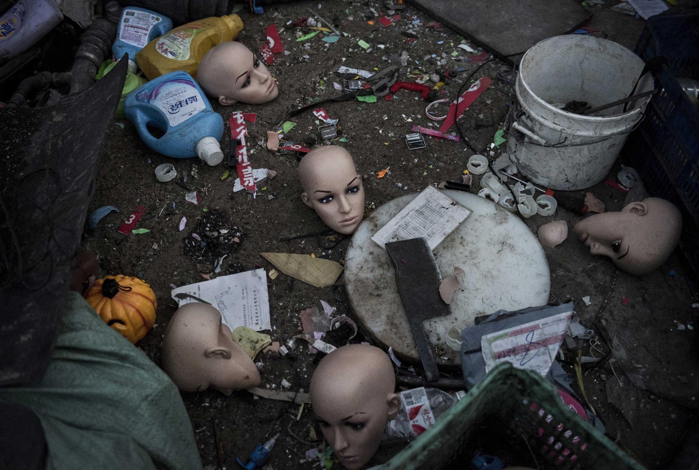Plastic mannequin heads and other items lay on the ground before being recycled in the Dong Xiao Kou village on Dec. 15, 2014 in Beijing.