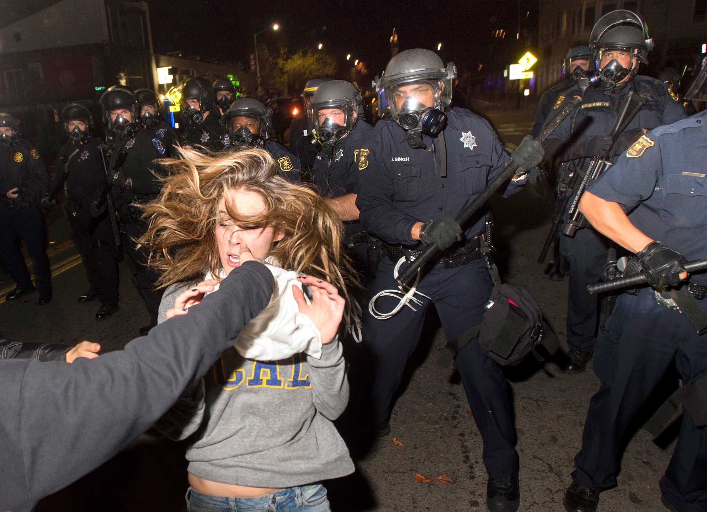 A protester flees as police officers try to disperse a crowd comprised largely of student demonstrators during a protest against police violence in the U.S., in Berkeley