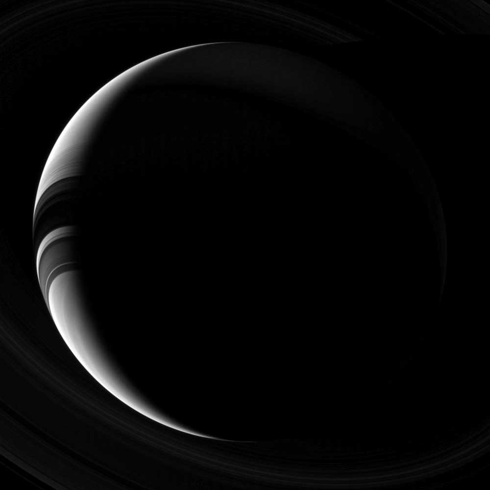 Saturn, which appears as a thin crescent, broken only by the shadows of its rings, was captured by the Cassini spacecraft cameras in this image released on March 17, 2014. This view looks toward the unilluminated side of the rings from about 42 degrees below the ringplane.