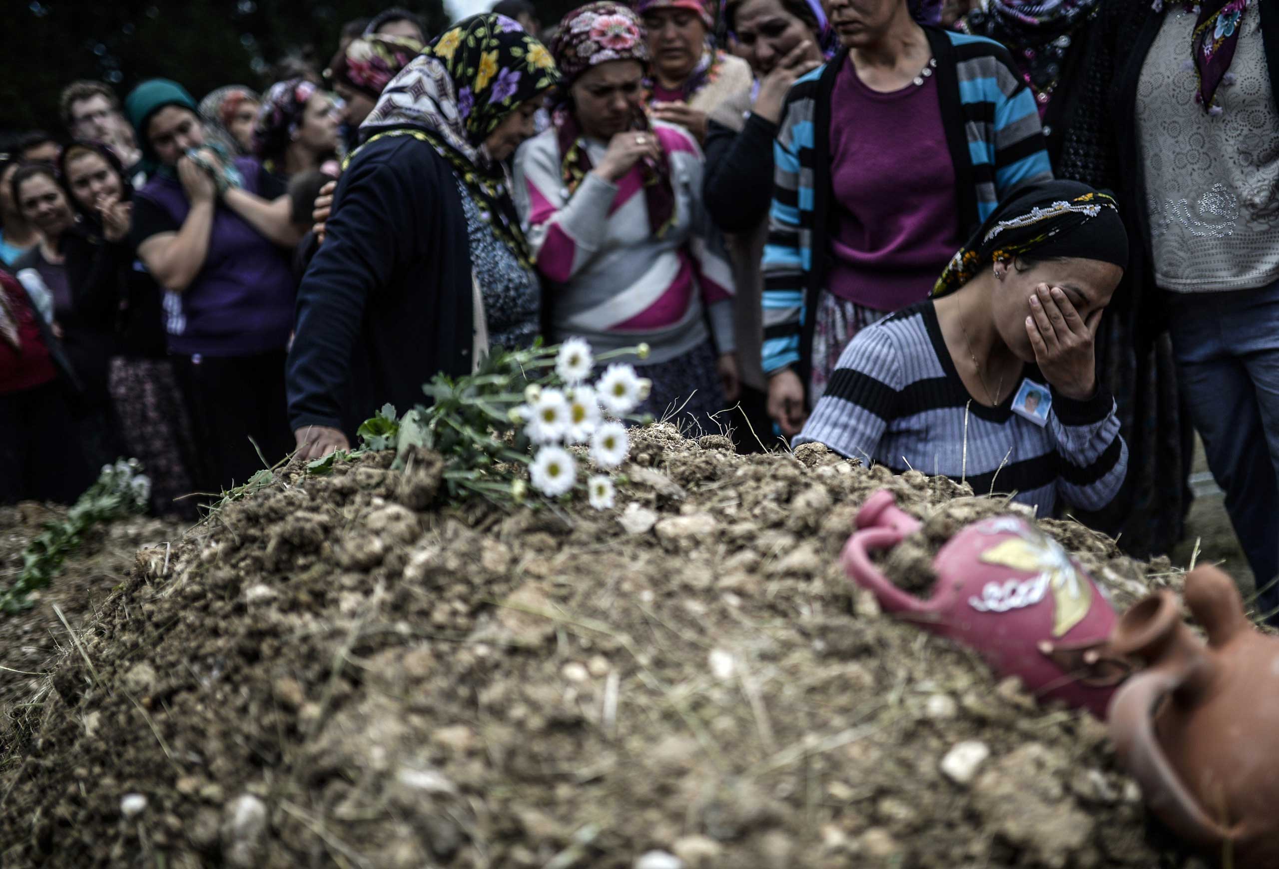 Duygu Colak, reacts as she sits in front of her husband Ugur's grave during a funeral ceremony in the western town of Soma in the Manisa province on May 15, 2014.