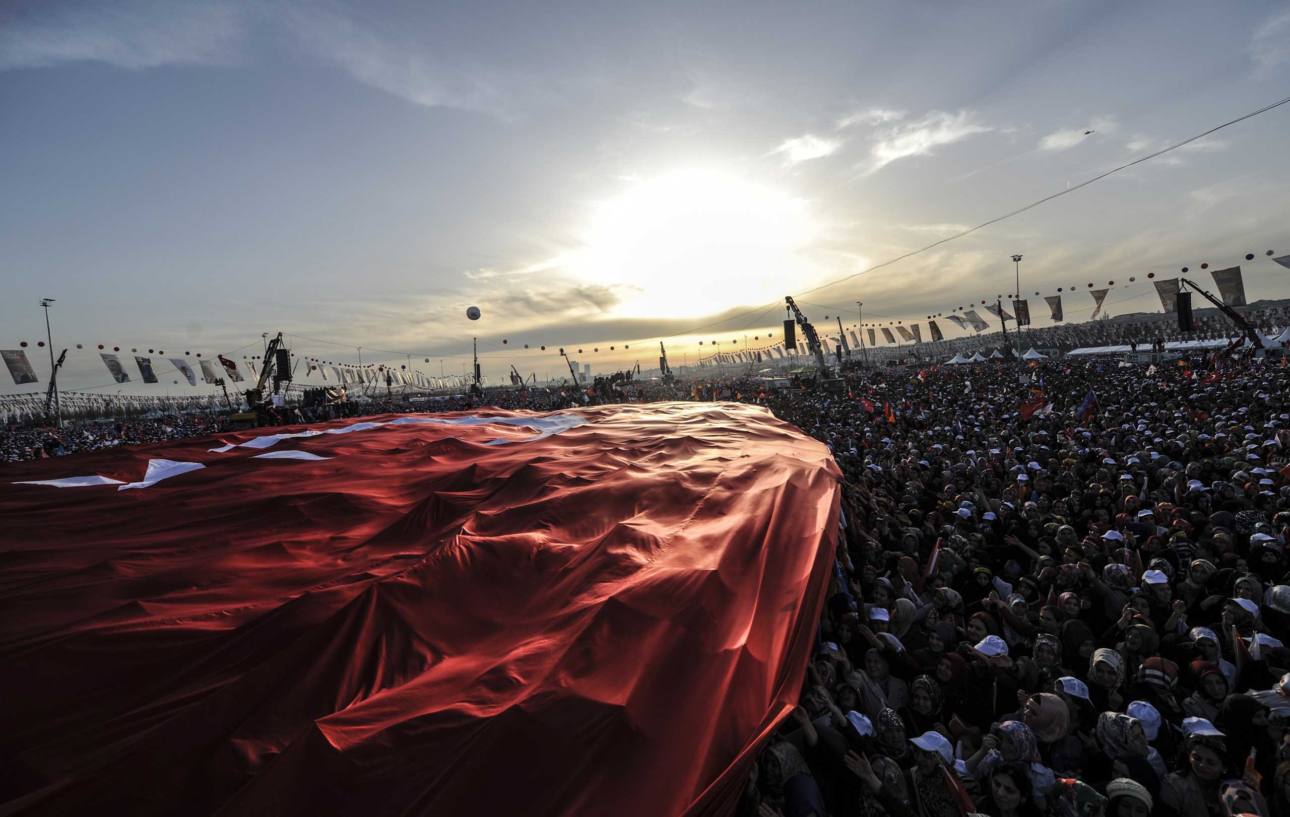 Supporters of Turkey's Prime Minister Tayyip Erdogan hold a giant Turkish flag during an election rally in Istanbul March 23, 2014.