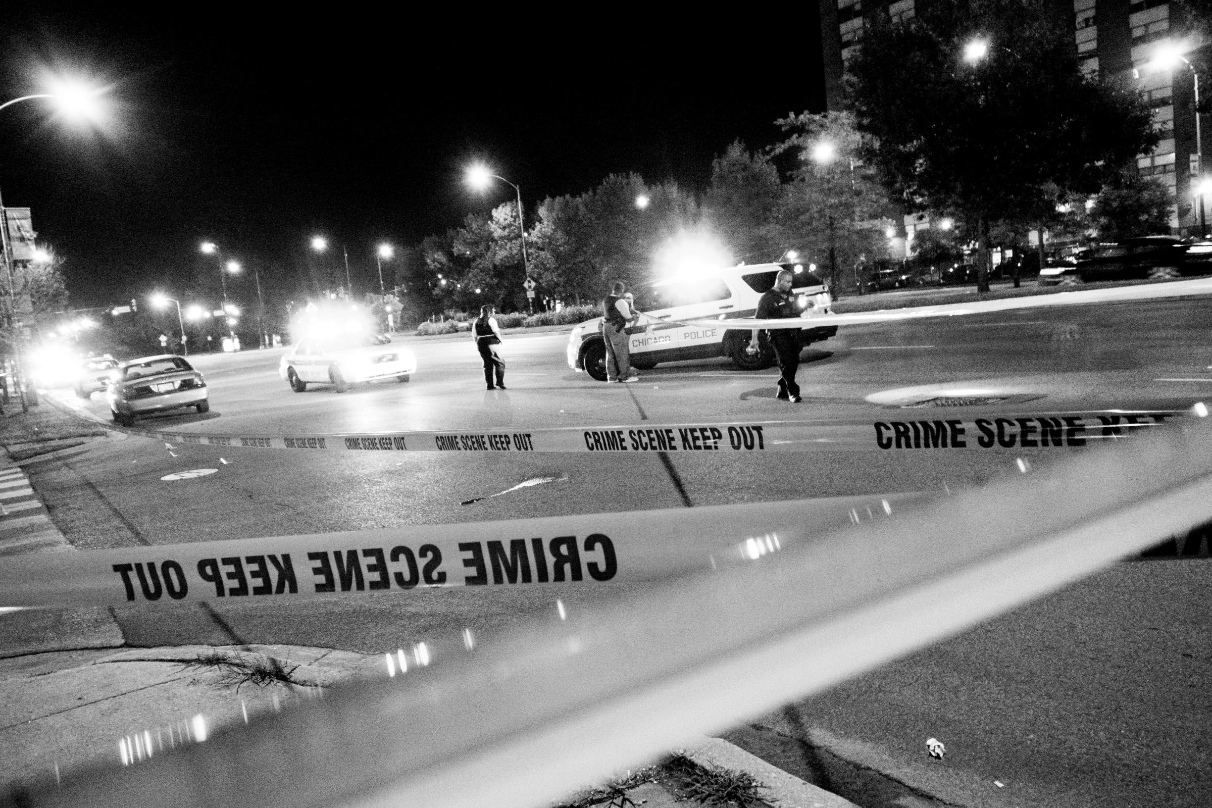 CHICAGO, IL. USA. September 2014Chicago police officers look for evidence after four people were hit as they stood in the parking lot of a Pizza Hut at 67th Street and Stony Island Avenue around 10:40 p.m. Monday Aug 25. A 16-year-old girl was shot in the thigh; a woman, 22, was wounded in the neck; another woman, 18, suffered a graze wound to the stomach; and a man, 26, was shot in the leg. Nobody died from their injuries ( Photo by Carlos Javier Ortiz)
