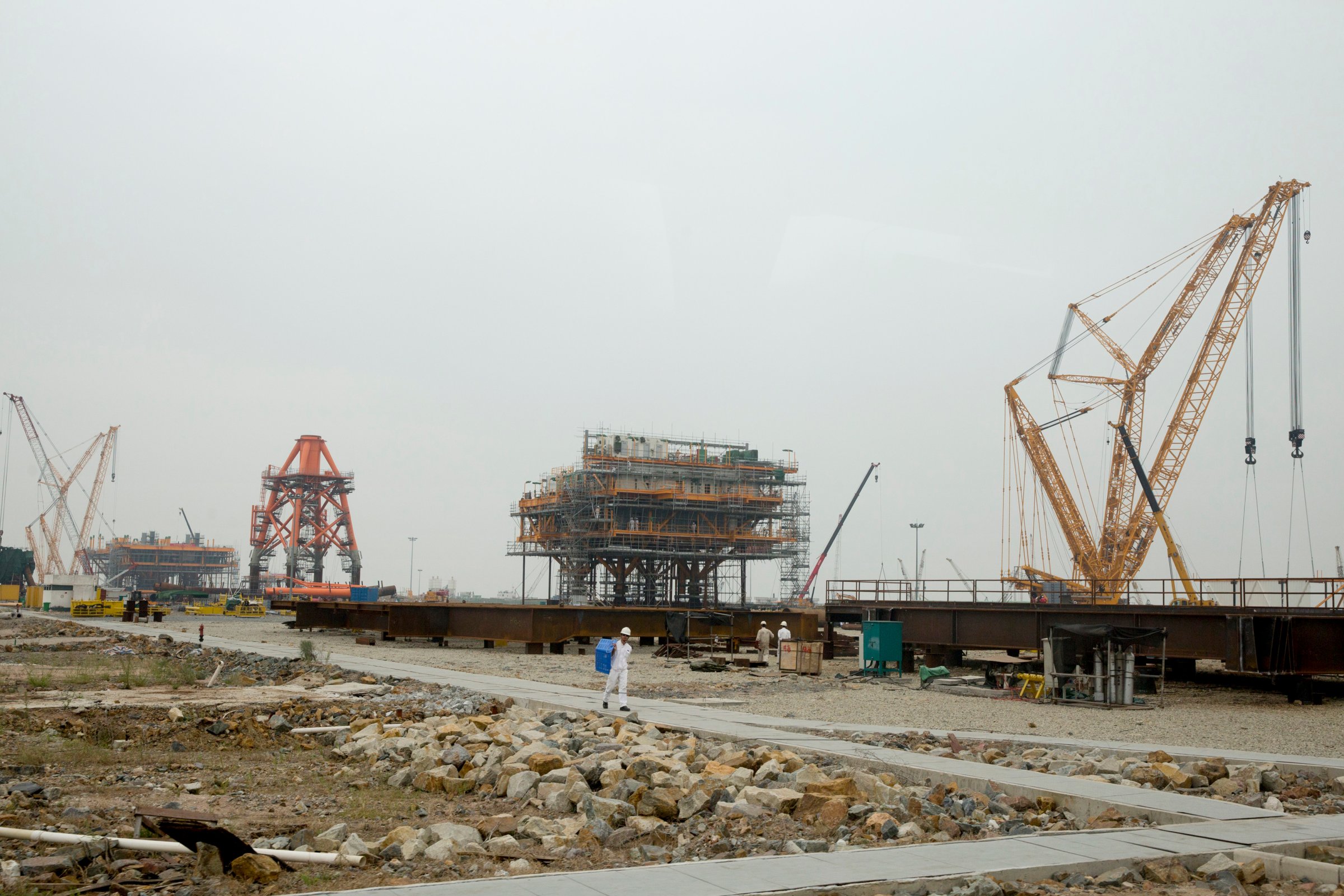 Cranes stand on a drilling platform construction site at the yard of Offshore Oil Engineering Co., a unit of CNOOC Ltd., in the Zhuhai Gaolan Port Economic Zone in Zhuhai, Guangdong province, China on Nov. 13, 2014.