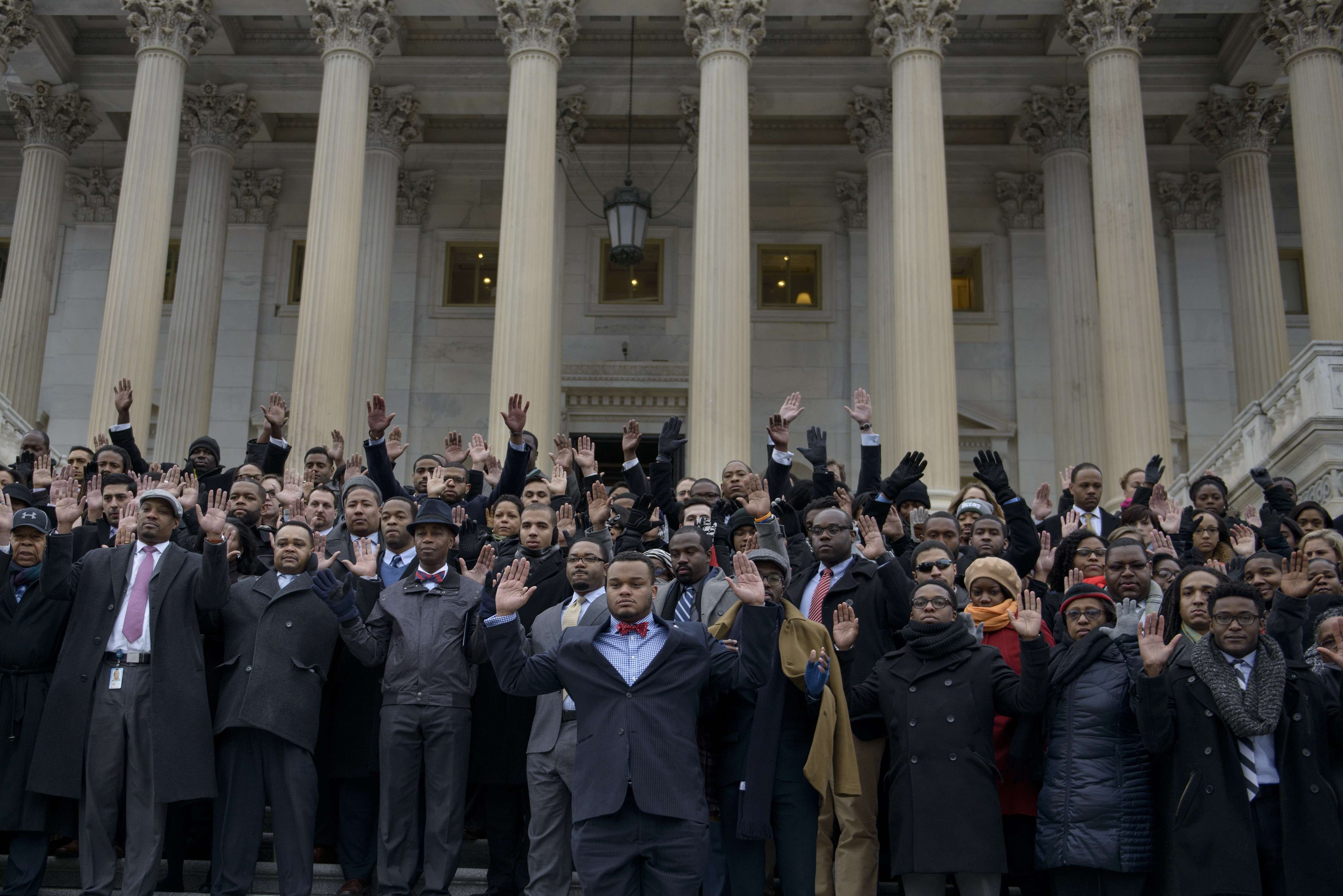 African-American Congressional staff and others hold their hands up during a walk-out outside the House on Capitol Hill on Dec. 11, 2014 in Washington D.C. (Brendan Smialowski—AFP/Getty Images)