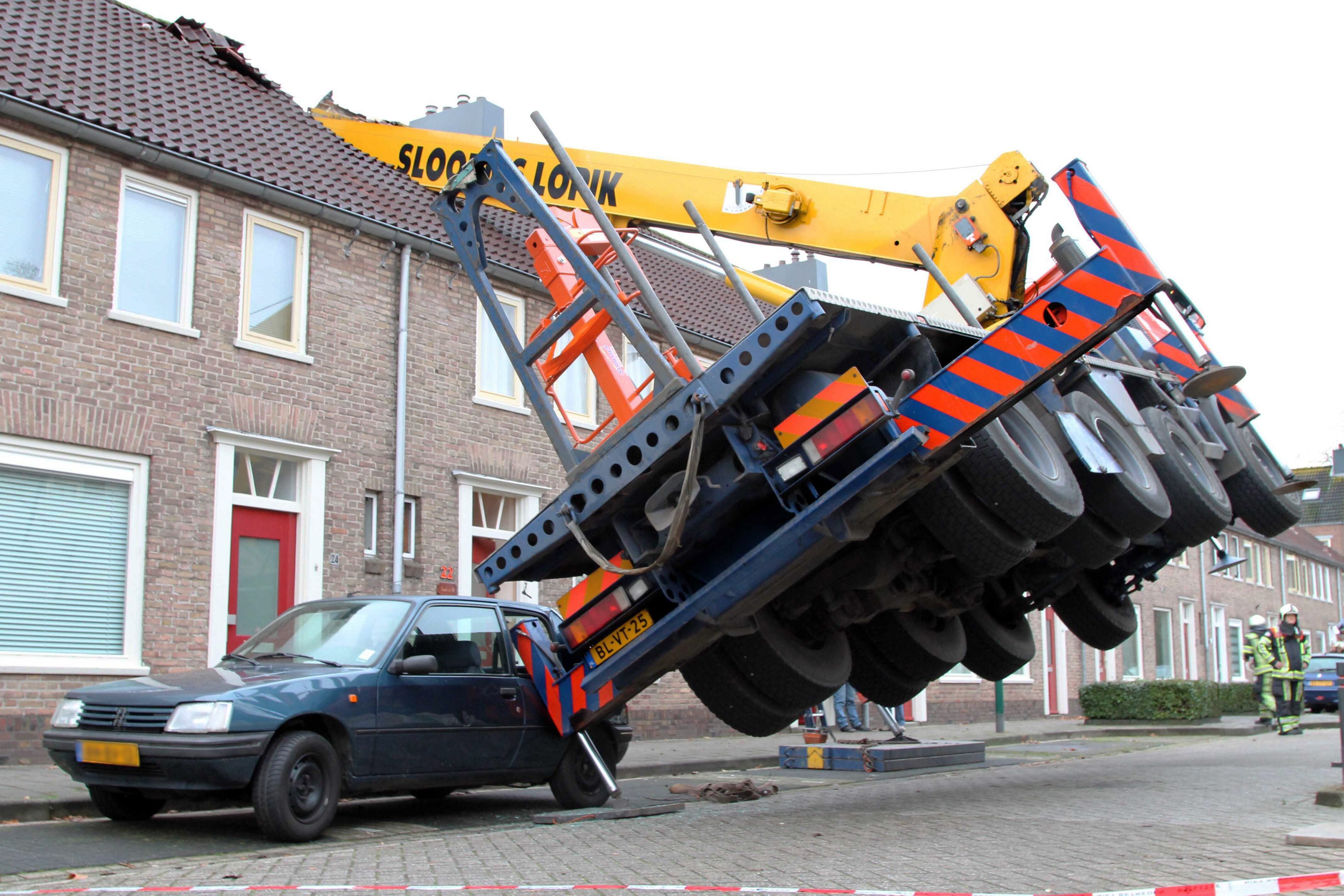 A crane fell on to the roof of a house in IJsselstein, Netherlands,  on Dec. 13, 2014. The incident ocurred when a man tried to surprise his girlfriend by proposing from the top of the crane, which then toppled on to the house, though no injuries were reported. (Michiel Van Beers—EPA)