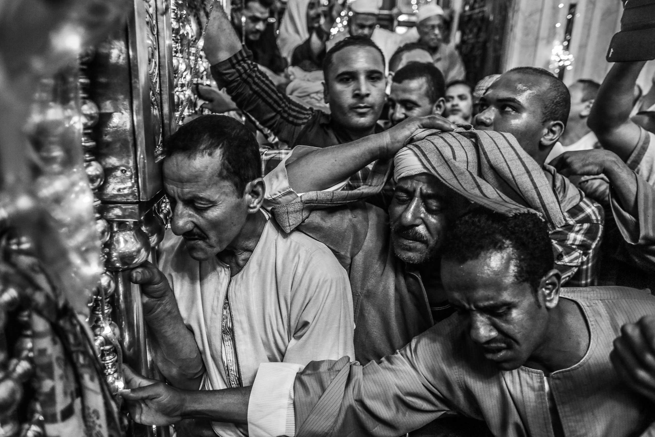 Worshippers surround the shrine of Sayeda Zeinab, granddaughter of the Prophet Muhammad, during the celebration of her birthday. Holding the shrine becomes the main goal for the thousands of attendees who then recite prayers or seek blessings through it. Downtown Cairo, Egypt. May 20, 2014.