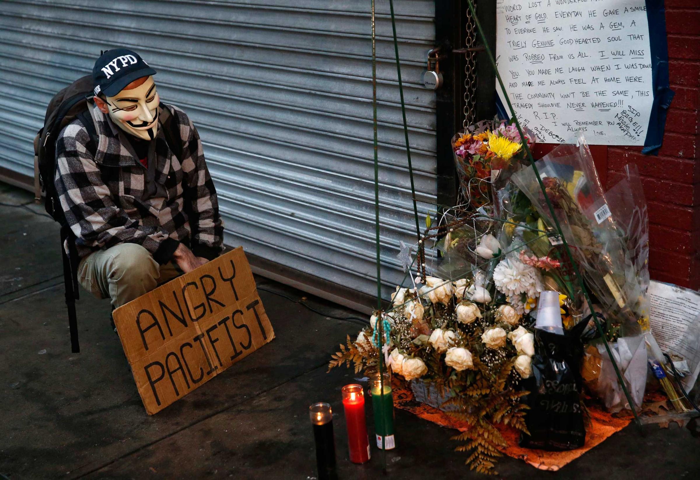 A demonstrator stands next to makeshift memorial where Eric Garner died during arrest in July in Staten Island borough of New York