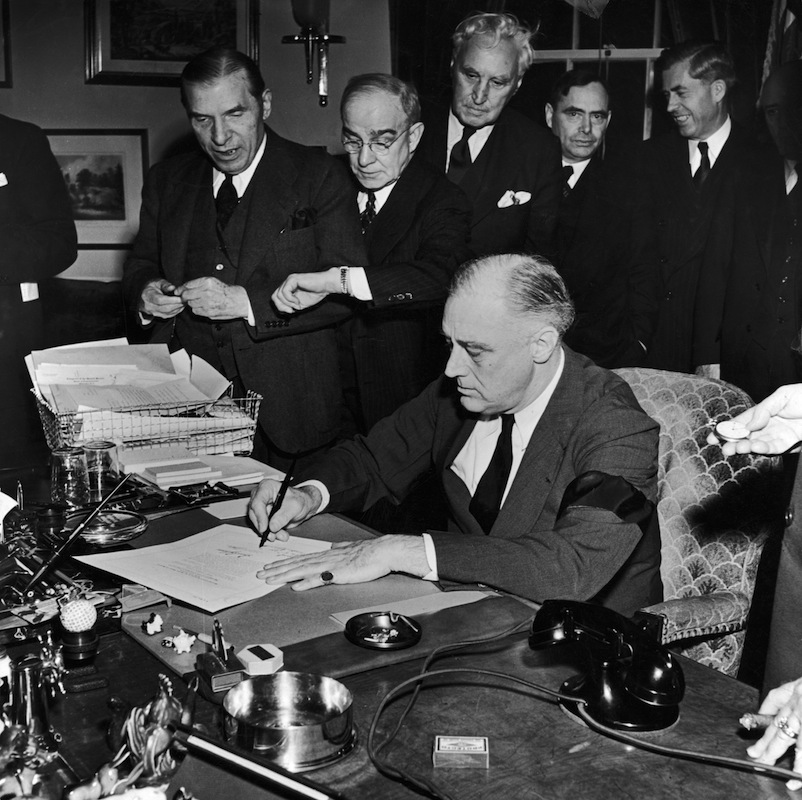 President Franklin D. Roosevelt (wearing black armband) signing declaration of war as others look on, following Japanese bombing of Pearl Harbor (Thomas D. McAvoy—The LIFE Picture Collection/Getty)