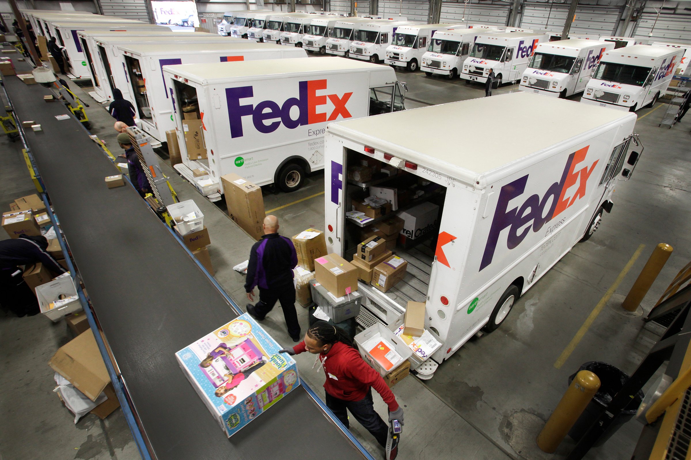 FedEx employees fill their trucks for deliveries at a FedEx sorting facility in the Bronx, New York on Dec. 15, 2014.