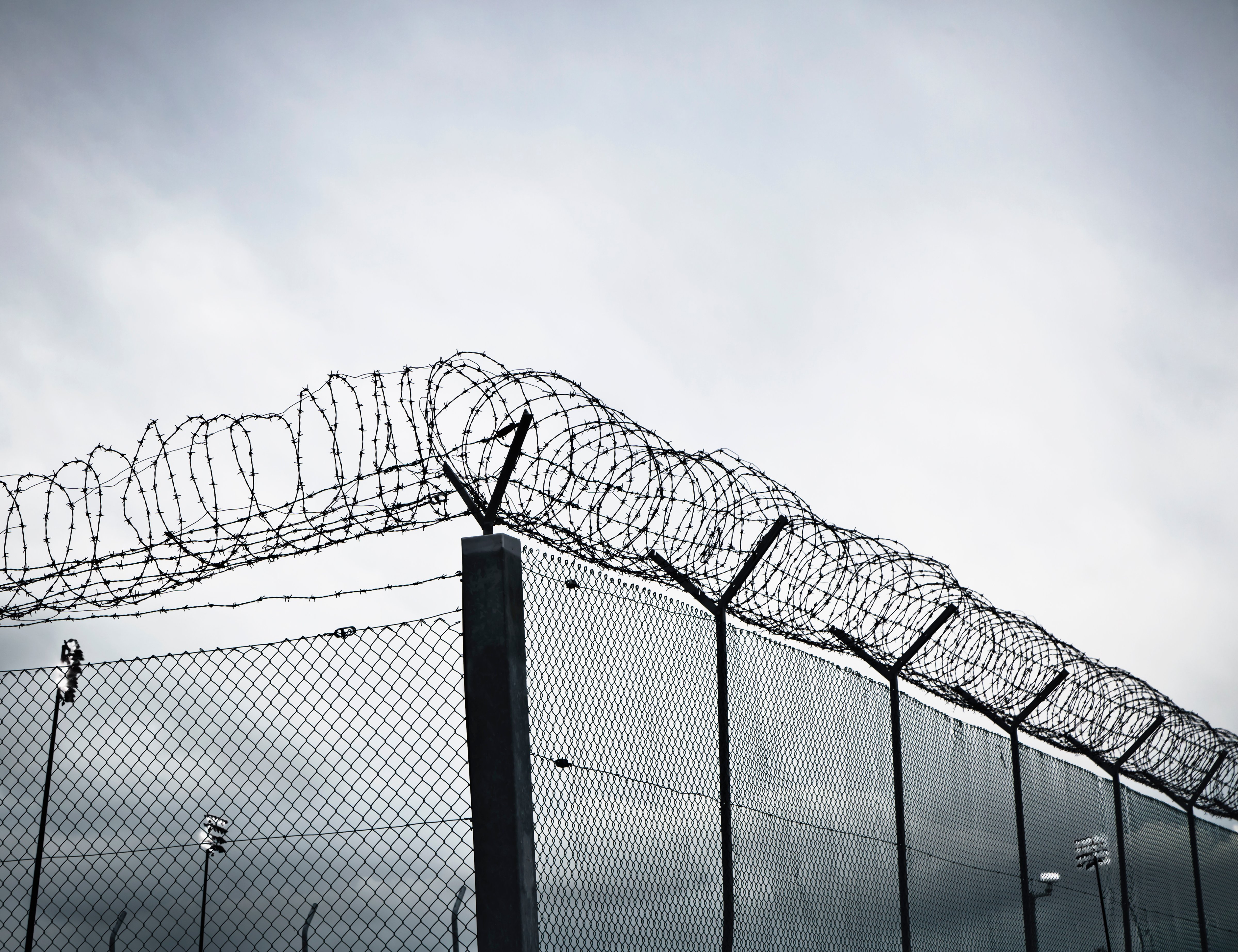 Chain link fence with barbed wire and razor wire