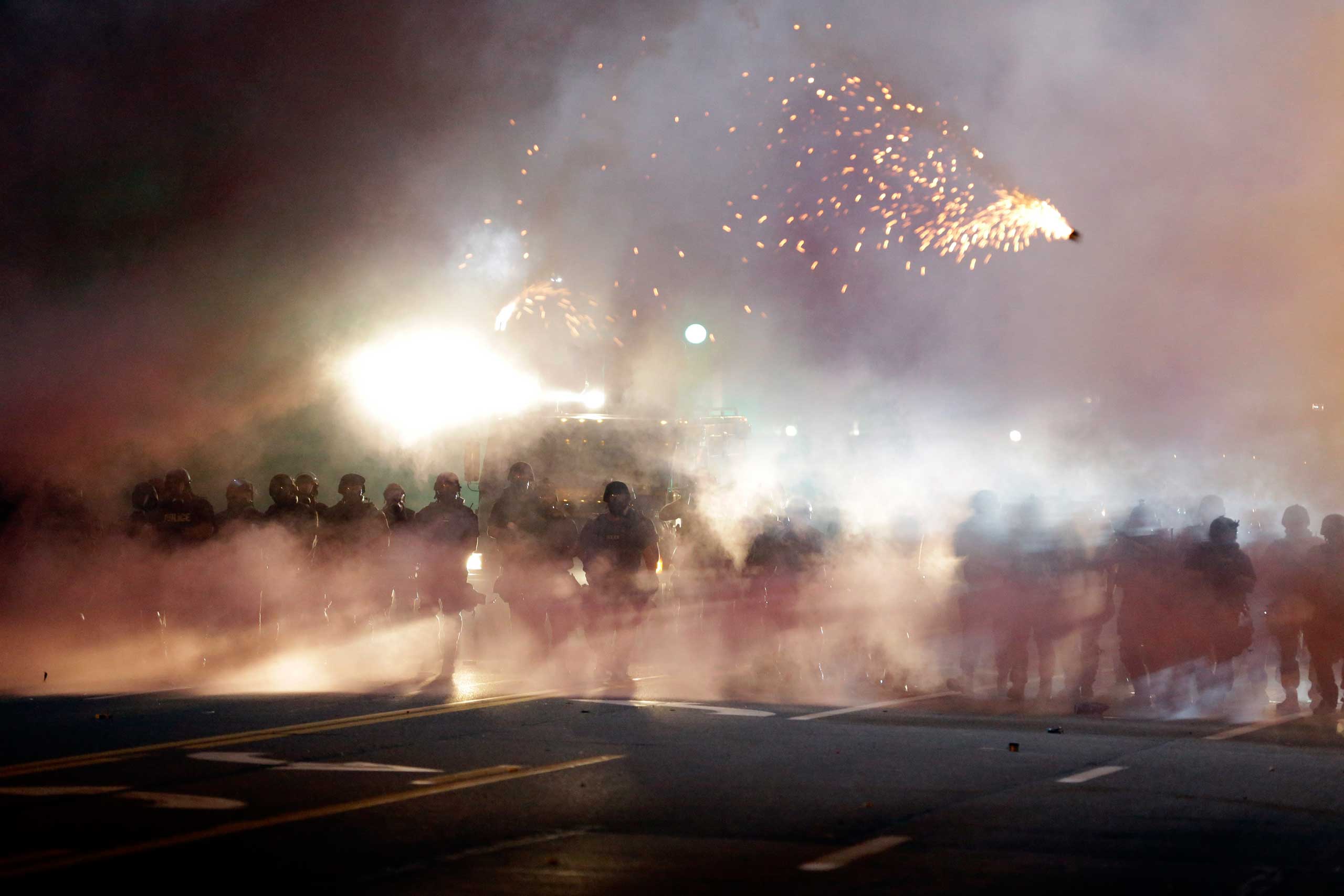 An explosive device deployed by police flies in the air as police and protesters clash after tear gas was thrown on Aug. 13, 2014, in Ferguson, Mo. (Jeff Roberson—AP)