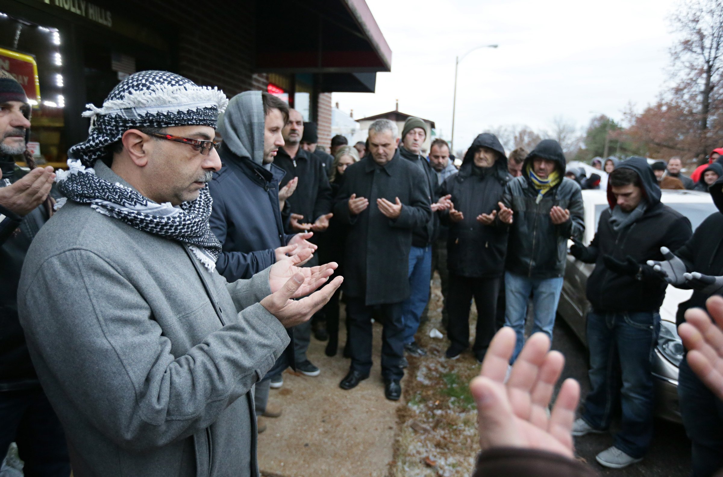 Zuhdi Masri, left, prays for murder victim Zemir Begic with a group of other Bosnians gathered on Holly Hills Avenue in St. Louis on Dec. 1, 2014.