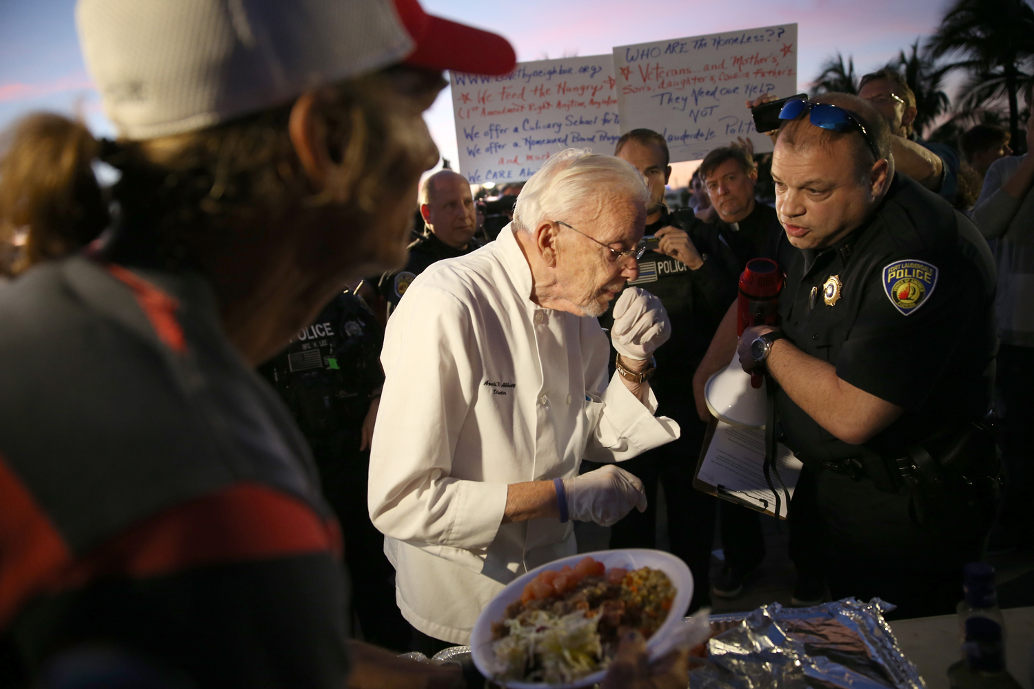 Fort Lauderdale Police Officer, Sgt. Al Lerner  (R), speaks with Arnold Abbott, a 90-year-old chef , as he warns him that he will be cited for feeding homeless in violation of a recently passed city law on November 12, 2014 in Fort Lauderdale, Florida. (Joe Raedle — Getty Images)