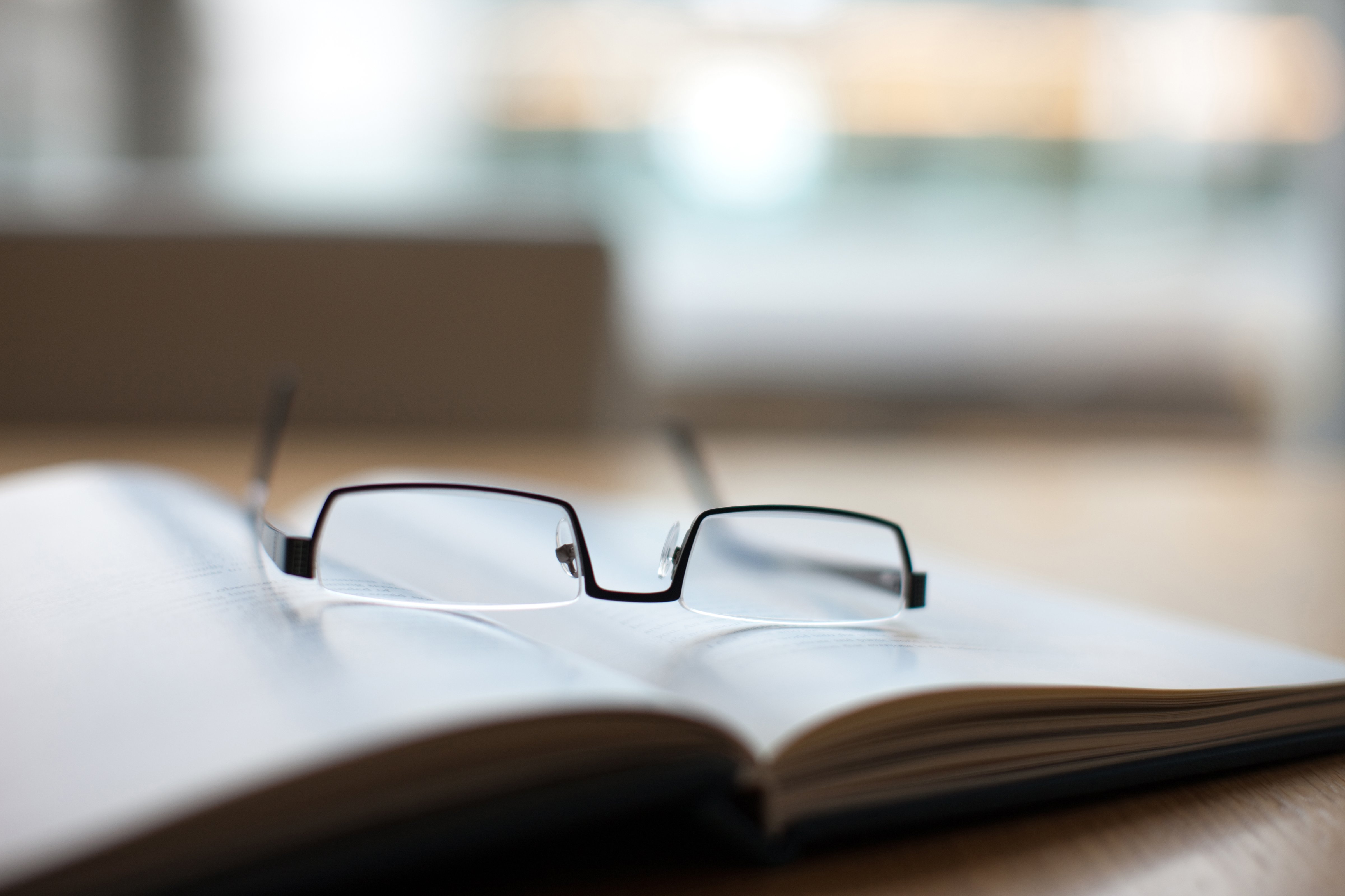 Eyeglasses and book on conference table