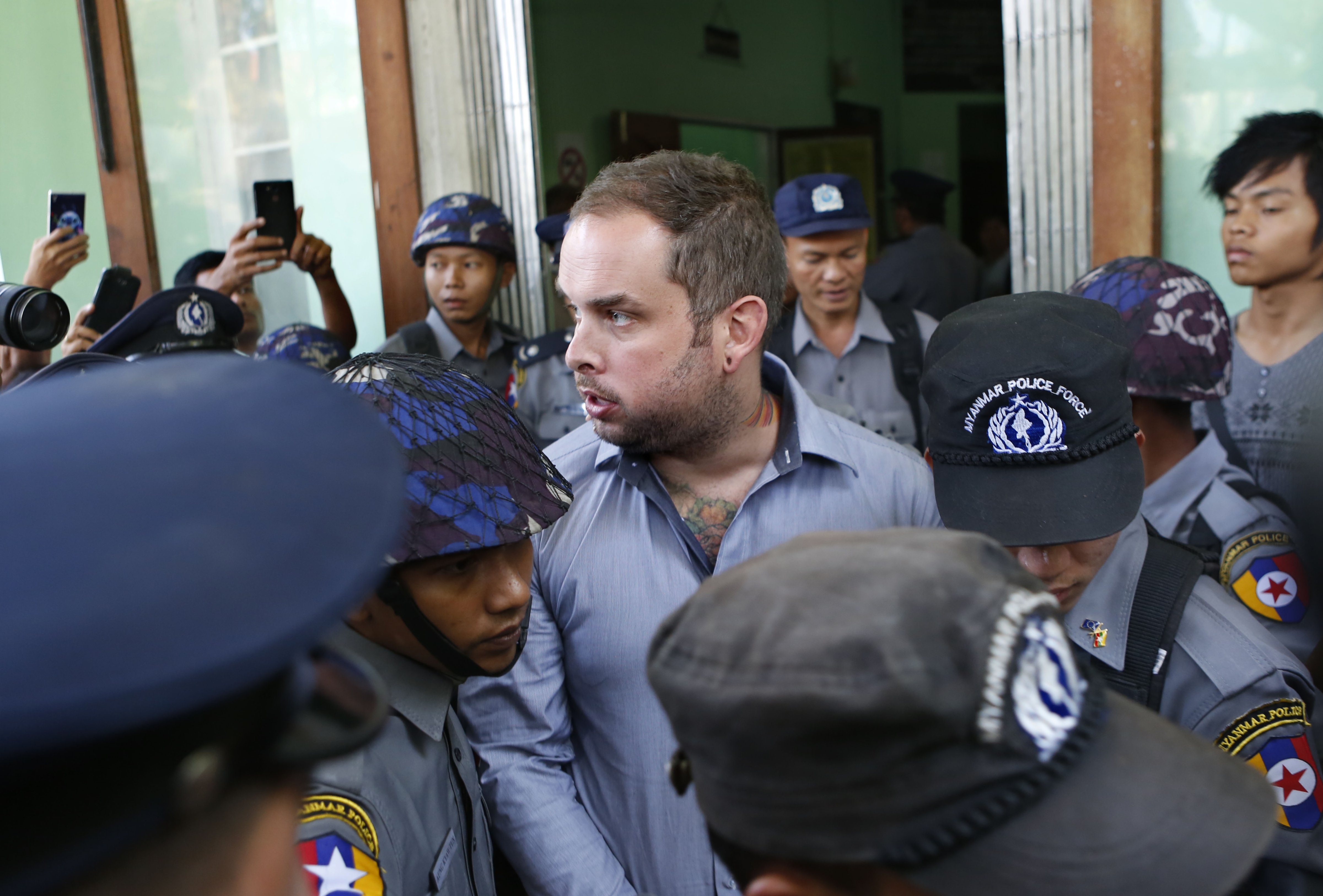 New Zealand citizen Philip Blackwood, center, is escorted by Burmese policemen after his hearing at a court in Rangoon on Dec. 18, 2014 (Lynn Bo Bo—EPA)