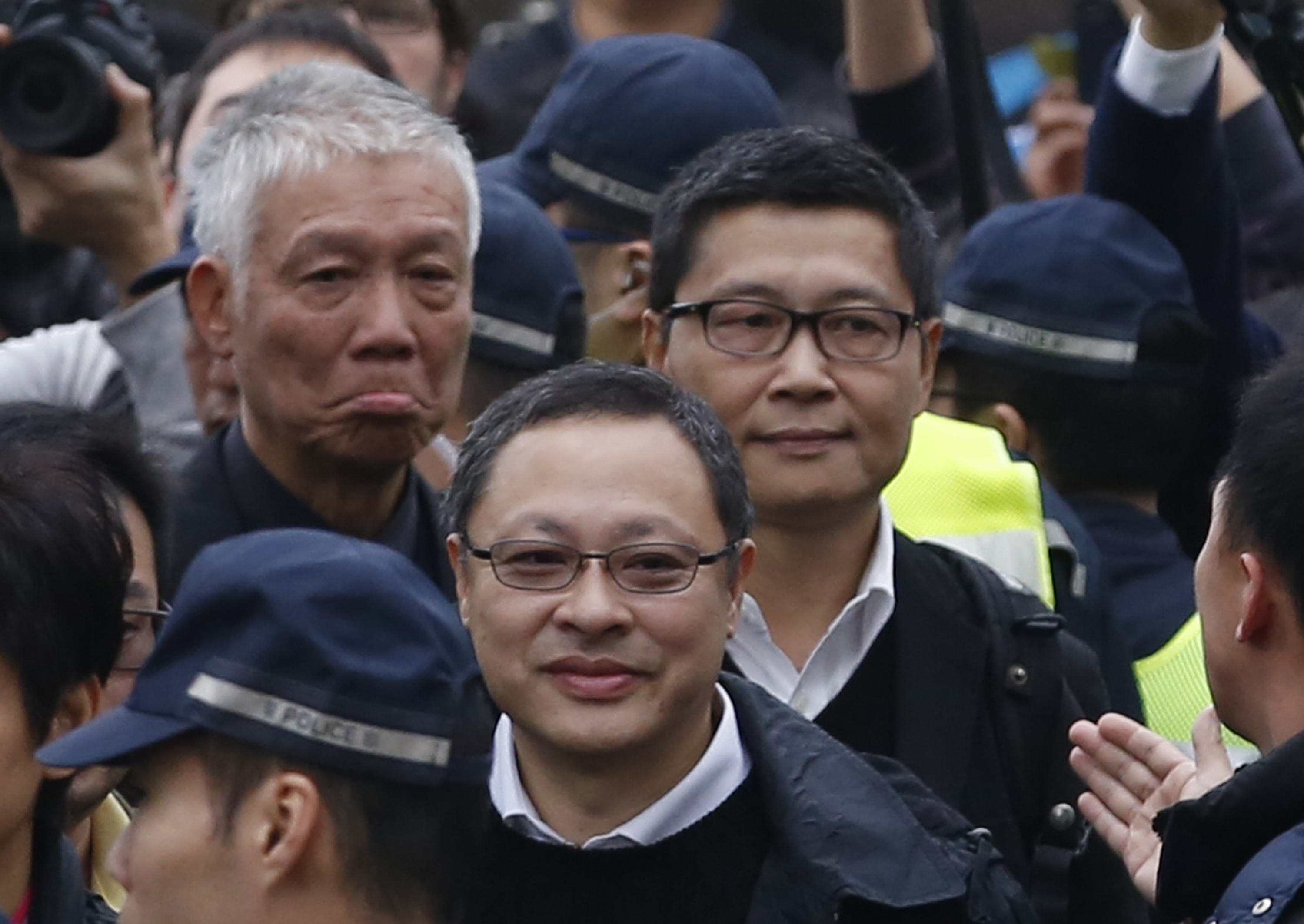 Three protest leaders, from right, Chan Kin-man, Benny Tai and the Rev. Chu Yiu-ming walk toward the police station in Hong Kong on Dec. 3, 2014, to surrender to police (Kin Cheung—AP)