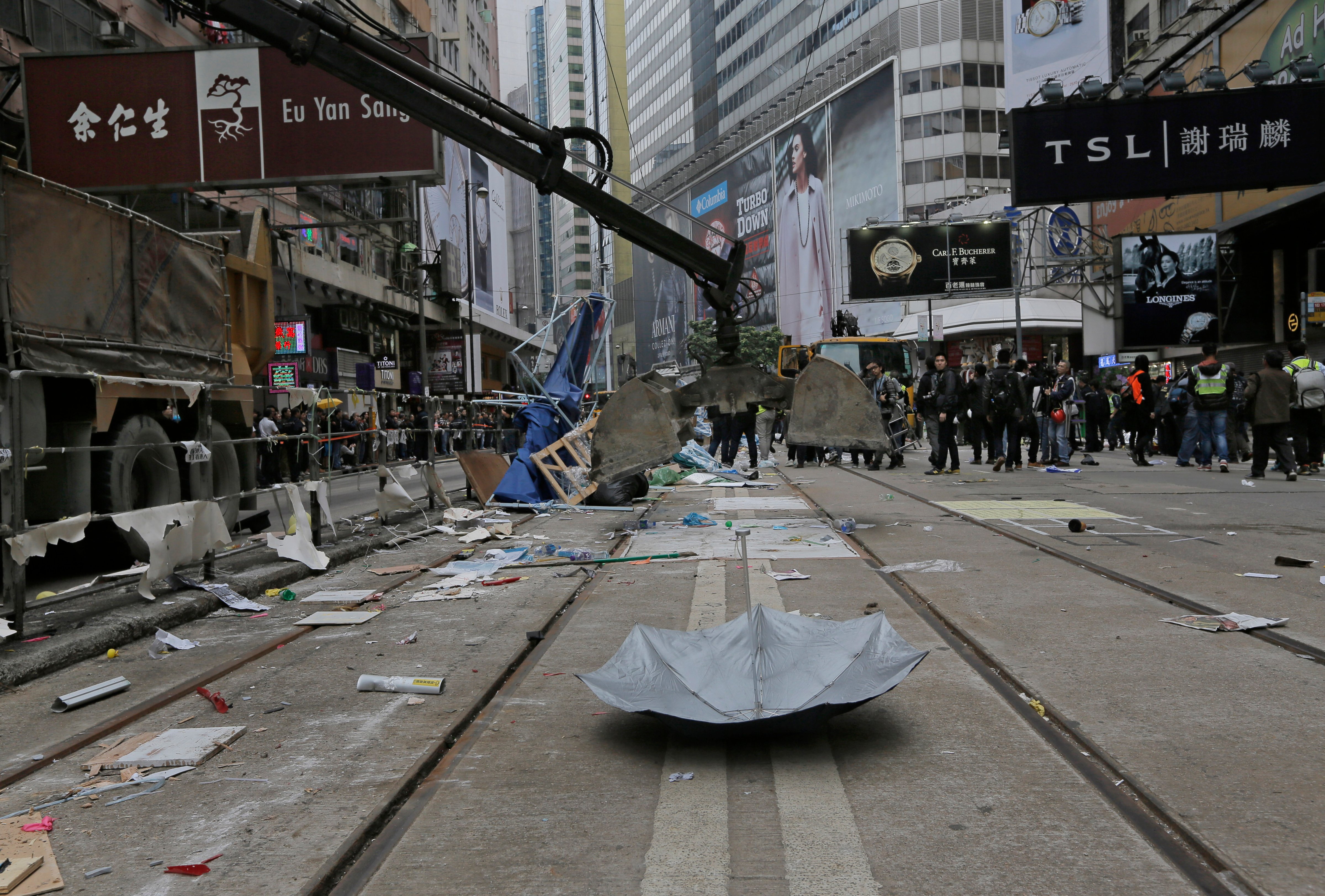 An excavation shovel is lowered to pick up an umbrella left behind by protesters as police clear barricades and tents on a main road in the occupied areas at Causeway Bay district in Hong Kong on Dec 15, 2014 (Vincent Yu—AP)