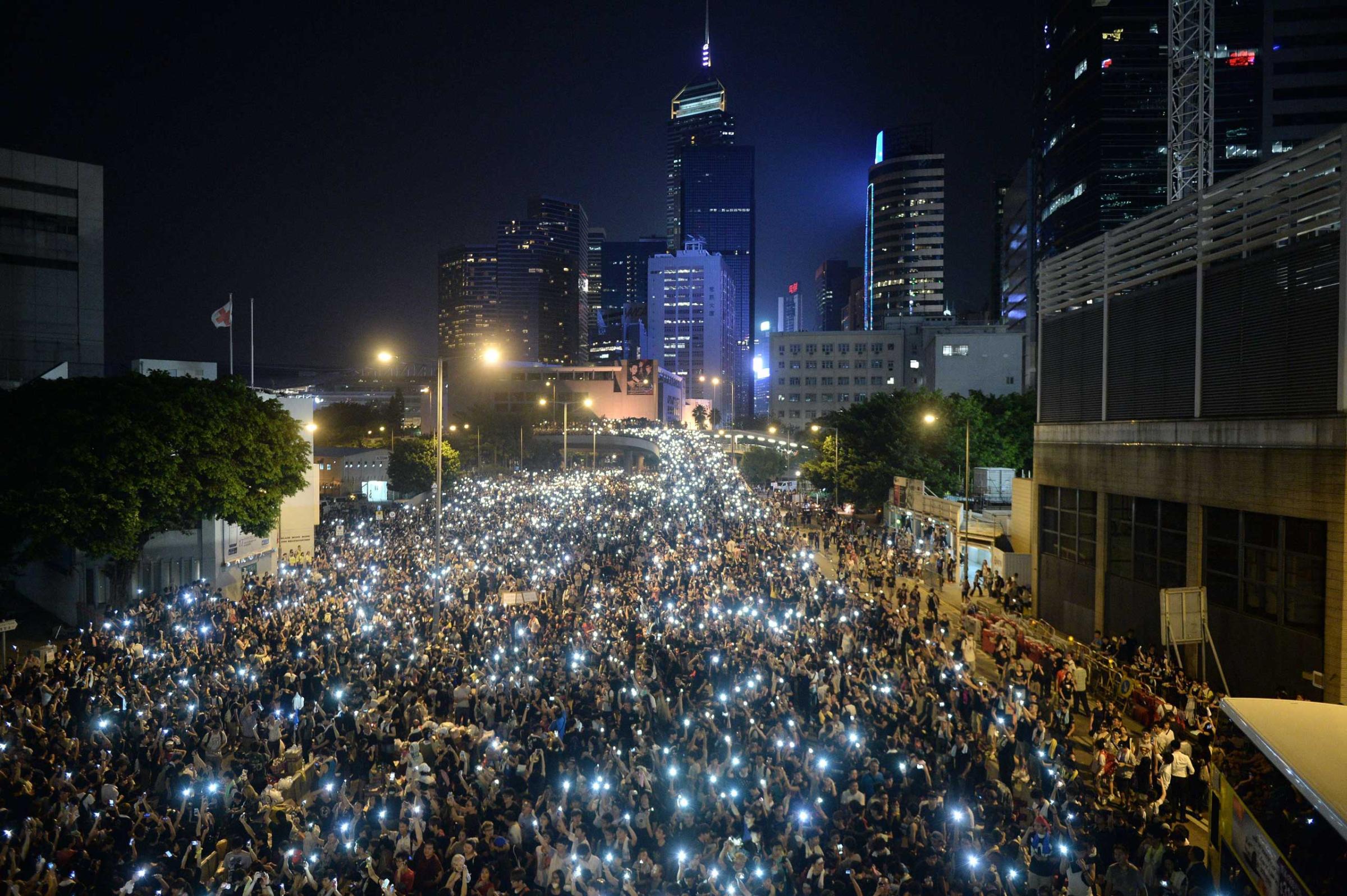 Pro-democracy demonstrators hold up their mobile phones during a protest near the Hong Kong government headquarters on Sept. 29, 2014.