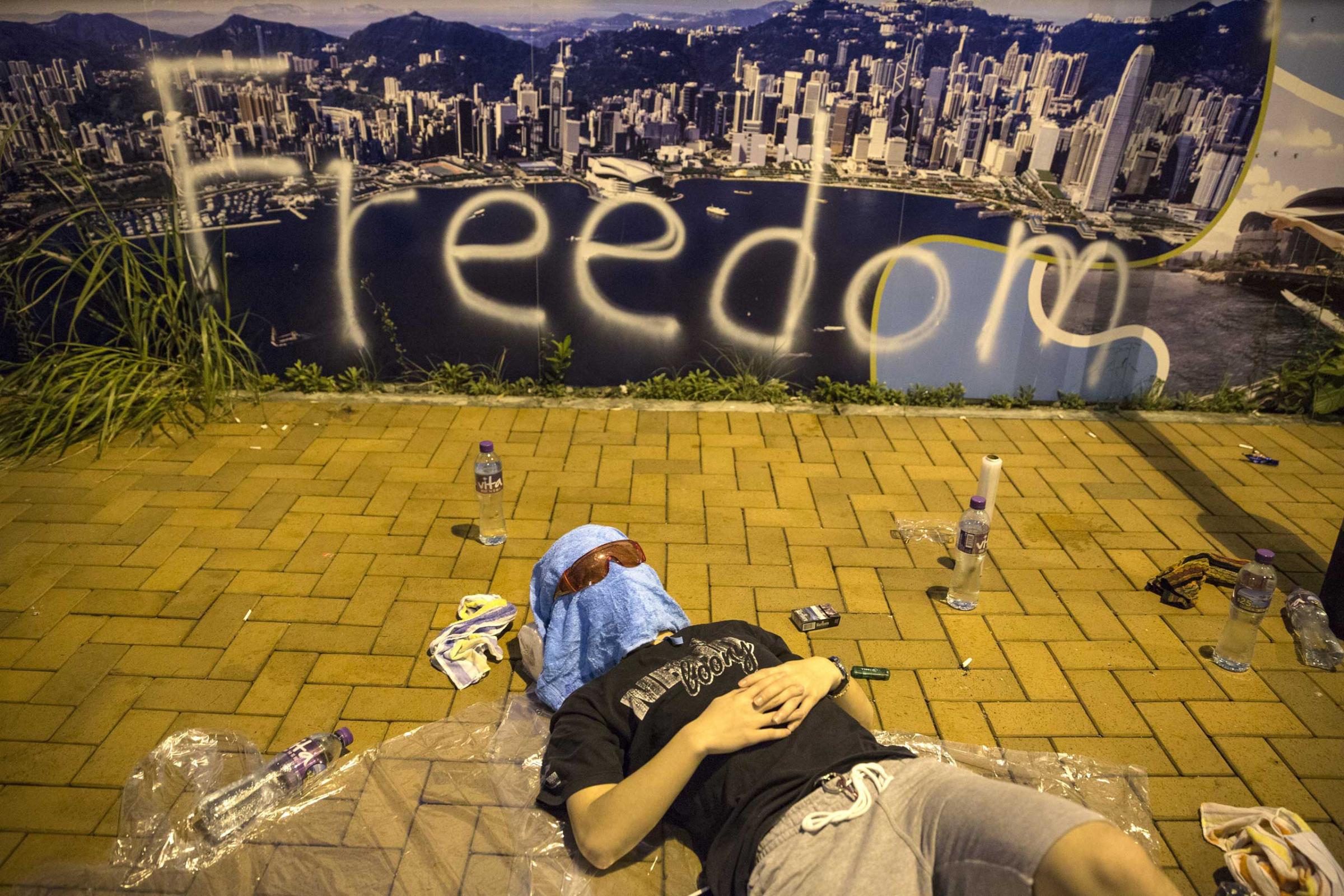 A protester sleeps on the streets outside the Hong Kong Government Complex at sunrise on Sept. 30, 2014 in Hong Kong.