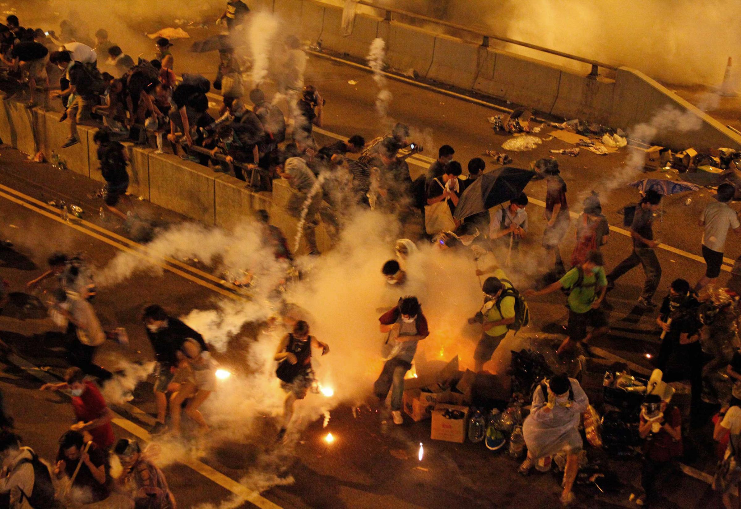 Riot police use tear gas against protesters after thousands of people blocked a main road at the financial central district in Hong Kong, Sept. 28, 2014.