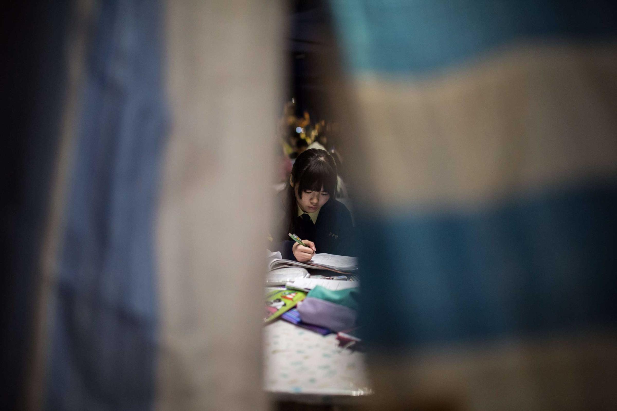 A young student studies in a makeshift classroom set up on a main road at a major pro-democracy protest site in the Admiralty district of Hong Kong on Dec. 1, 2014.