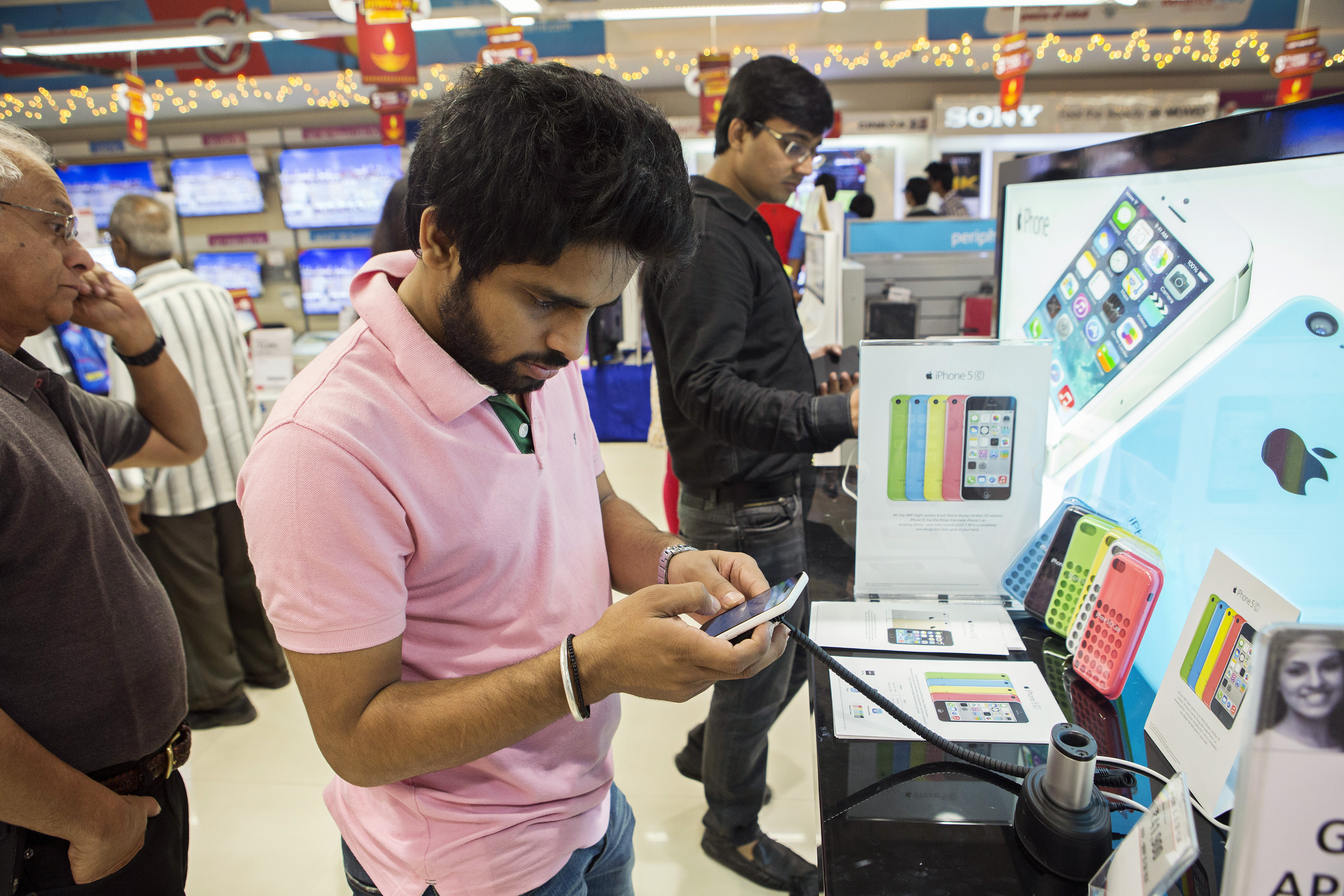 A customer tries out an Apple Inc. iPhone 5C at a Reliance Digital store, a subsidiary of Reliance Industries Ltd., in New Delhi, India, on Saturday, Nov. 2, 2013. (Bloomberg&mdash;Bloomberg via Getty Images)