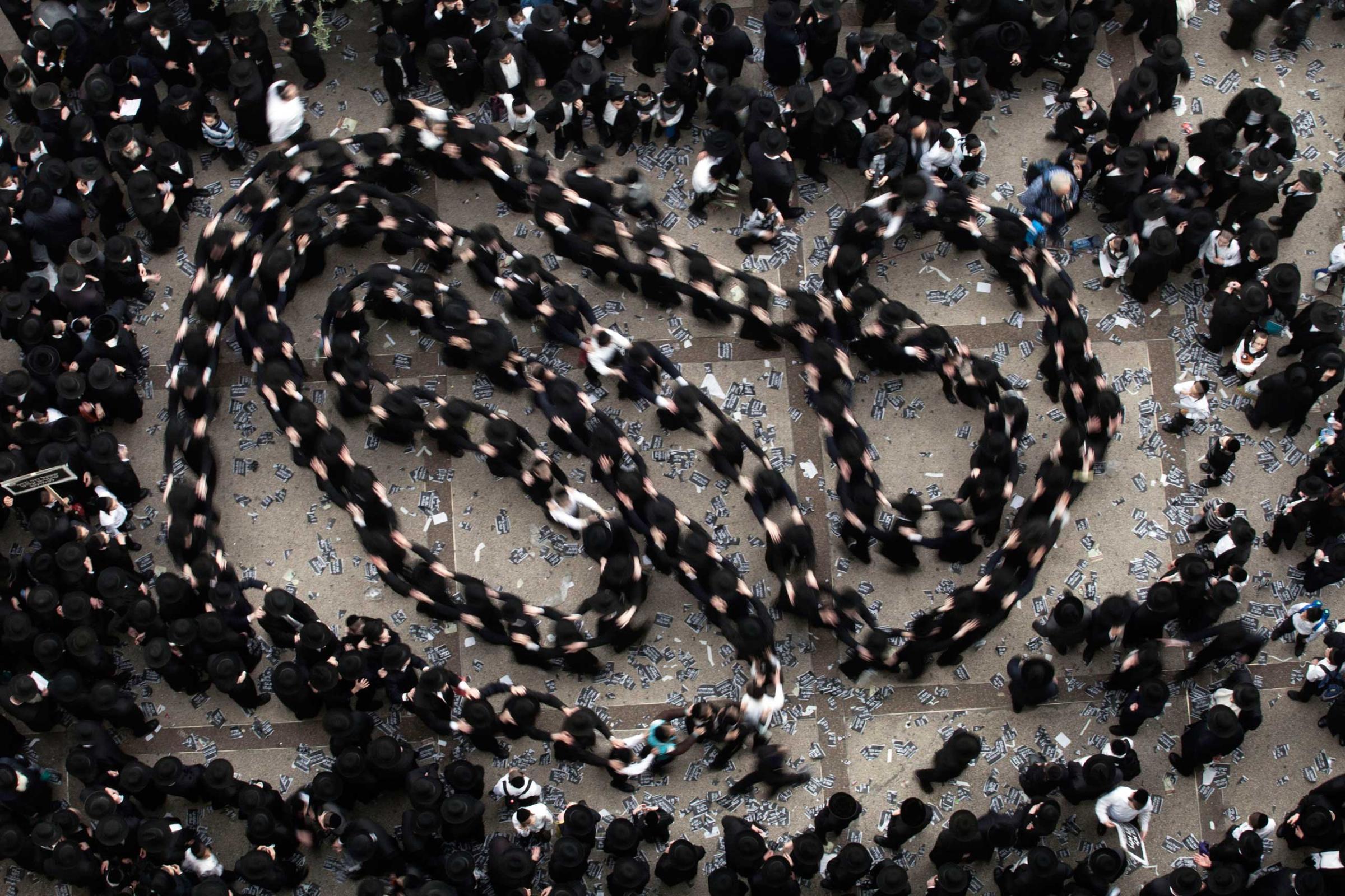 Ultra-Orthodox Jews dance as they gather for a mass prayer in protest to the government's army conscription laws in Jerusalem, March 2, 2014.