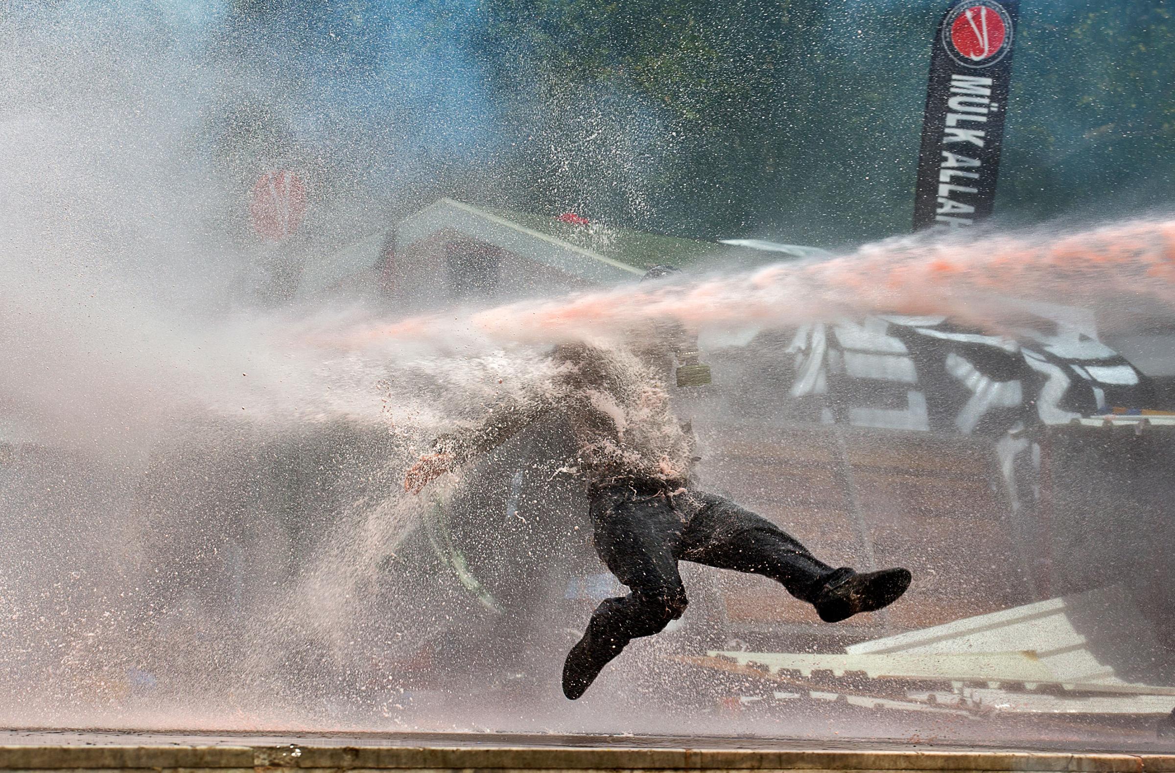 A protester is hit by a water cannon during clashes in Taksim Square, Istanbul on June 11, 2013.