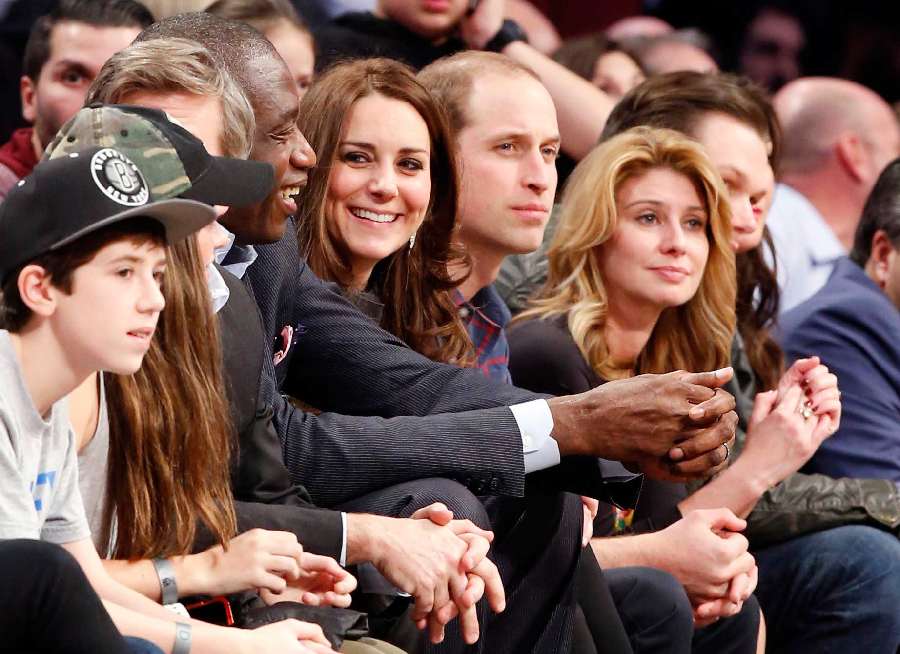 Former Houston Rockets player Dikembe Mutombo talks to the Duchess as they sit courtside.