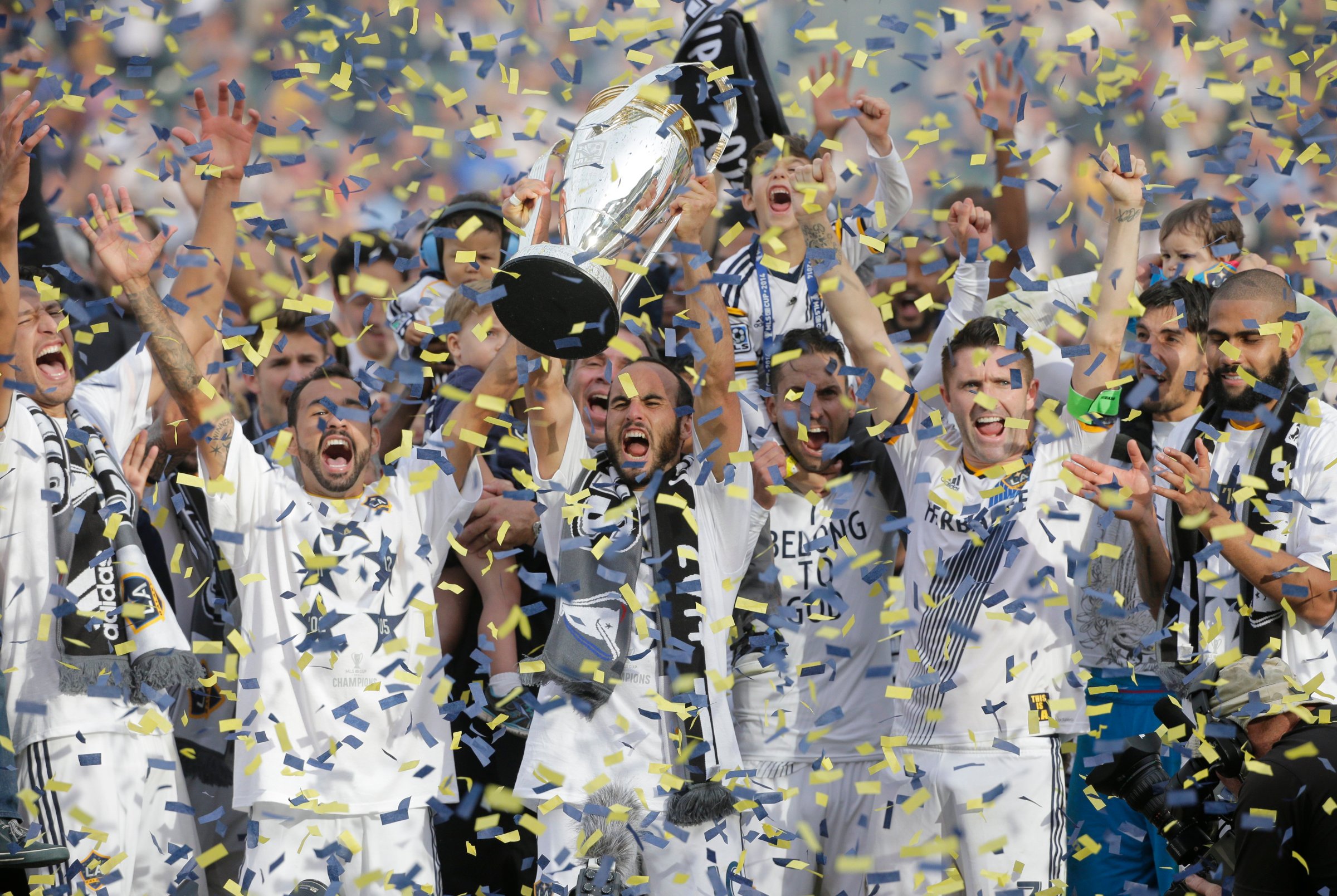 Los Angeles Galaxy's Landon Donovan hoists the trophy as he and teammates celebrate after winning the MLS Cup championship soccer match against the New England Revolution on Dec. 7, 2014, in Carson, Calif.