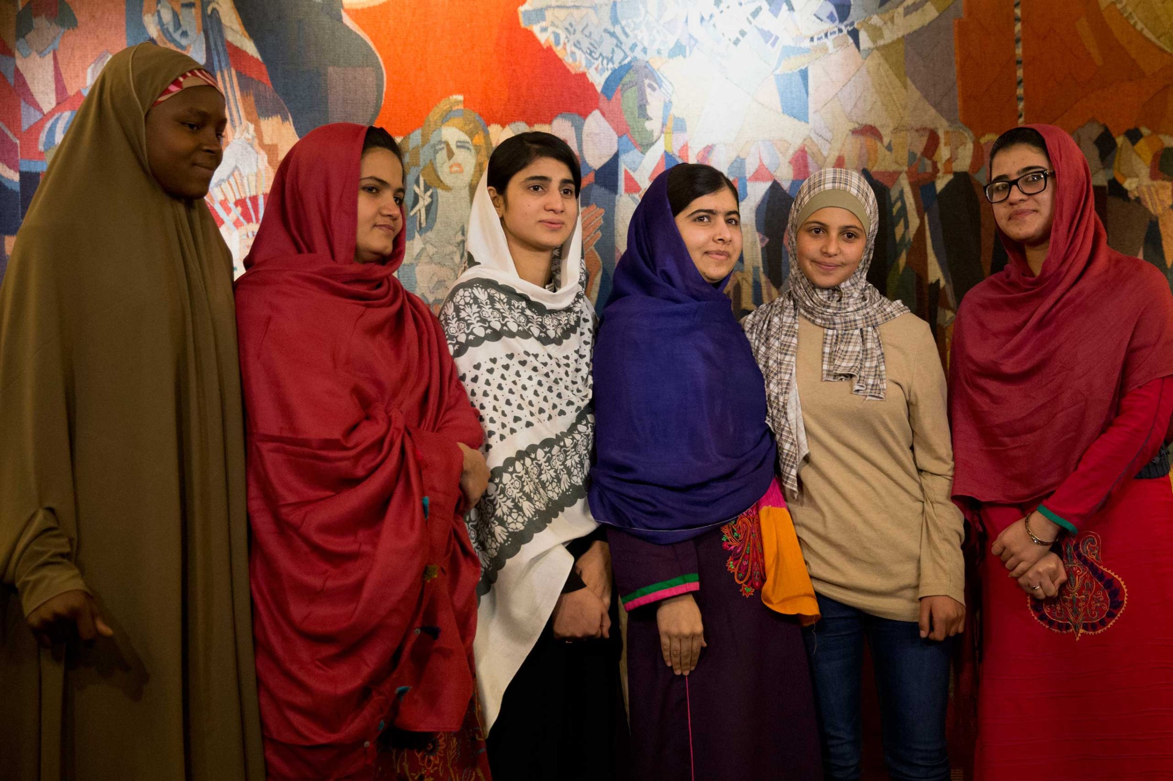 Joint Nobel Peace prize winner Malala Yousafzai, stands with five young women she invited to attend the Nobel Peace Prize ceremony, from left, Nigeria's Amina Yusuf, Pakistan's Kainat Soomro, school friend Shazia Ramzan, Syria's Mezon Almellehan and school friend Kainat Riaz, as they pose for a group photograph before speaking to the media at Malala's hotel in Oslo, Norway, Dec. 9, 2014.
