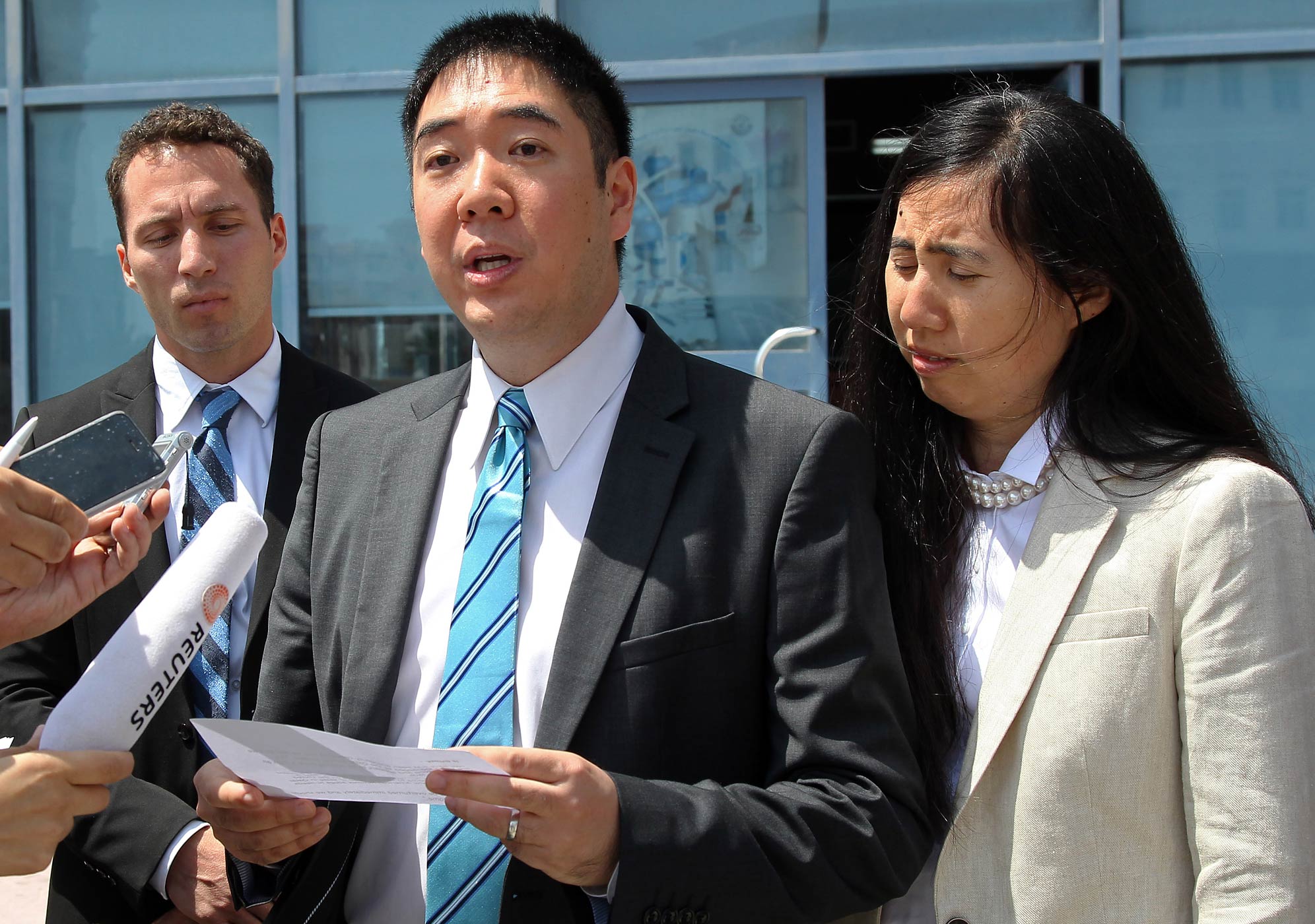 Matthew, left, and Grace Huang, an American couple charged with starving to death their 8-year-old adopted daughter, speak to the press outside the a courthouse before their trial in Doha, Qatar, Thursday, March 27, 2014. (Osama Faisal—AP)