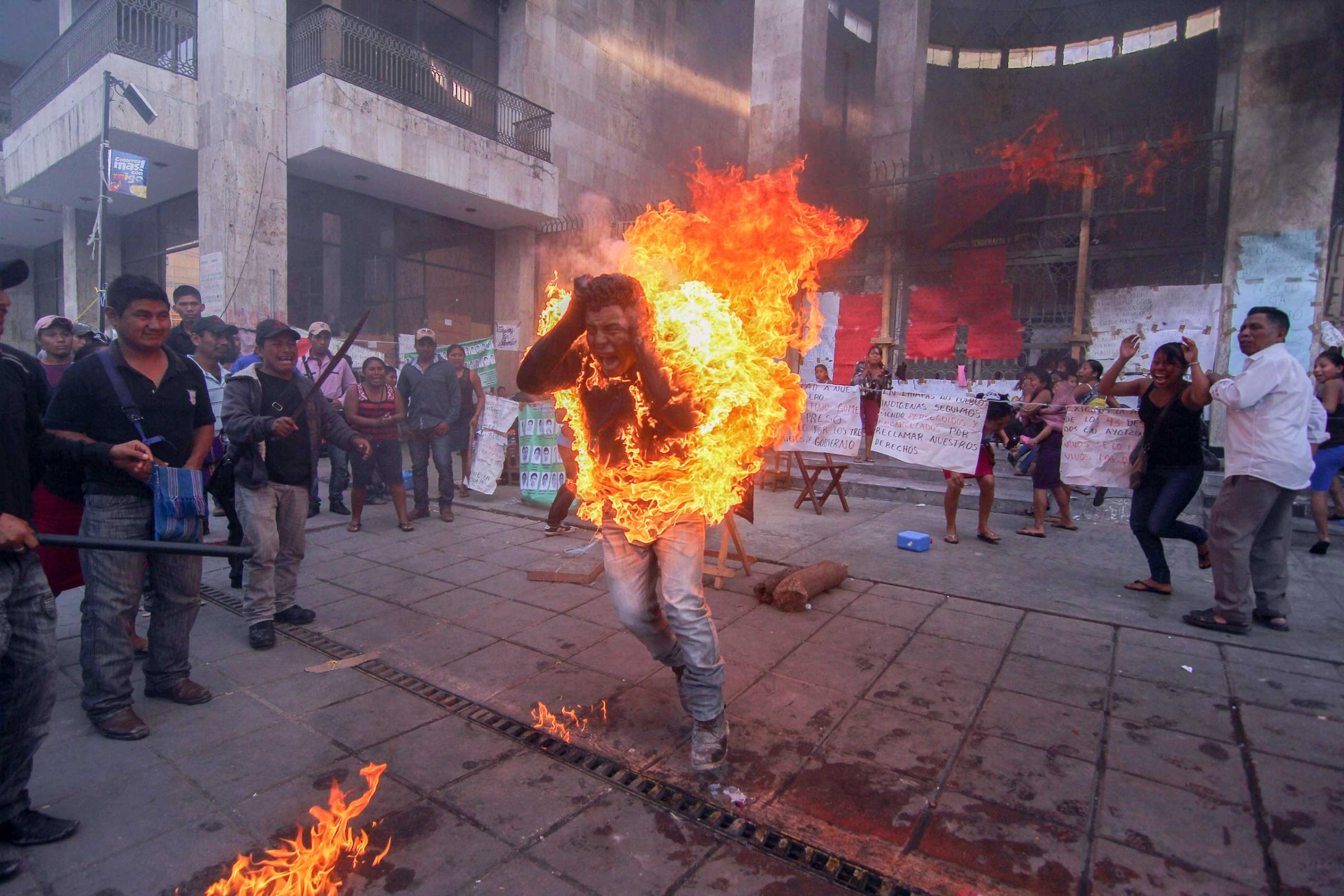 Farmer Agustin Gomez Perez, 21, runs engulfed in flames after he was lit on fire as a form of protest outside the Chiapas state legislature in Tuxtla Gutierrez, Mexico, Dec. 5, 2014. Perez was demanding the release of his father, indigenous leader Florentino Gomez Giron, who was arrested last year on charges stemming from a series of demonstrations in 2011 that turned violent.