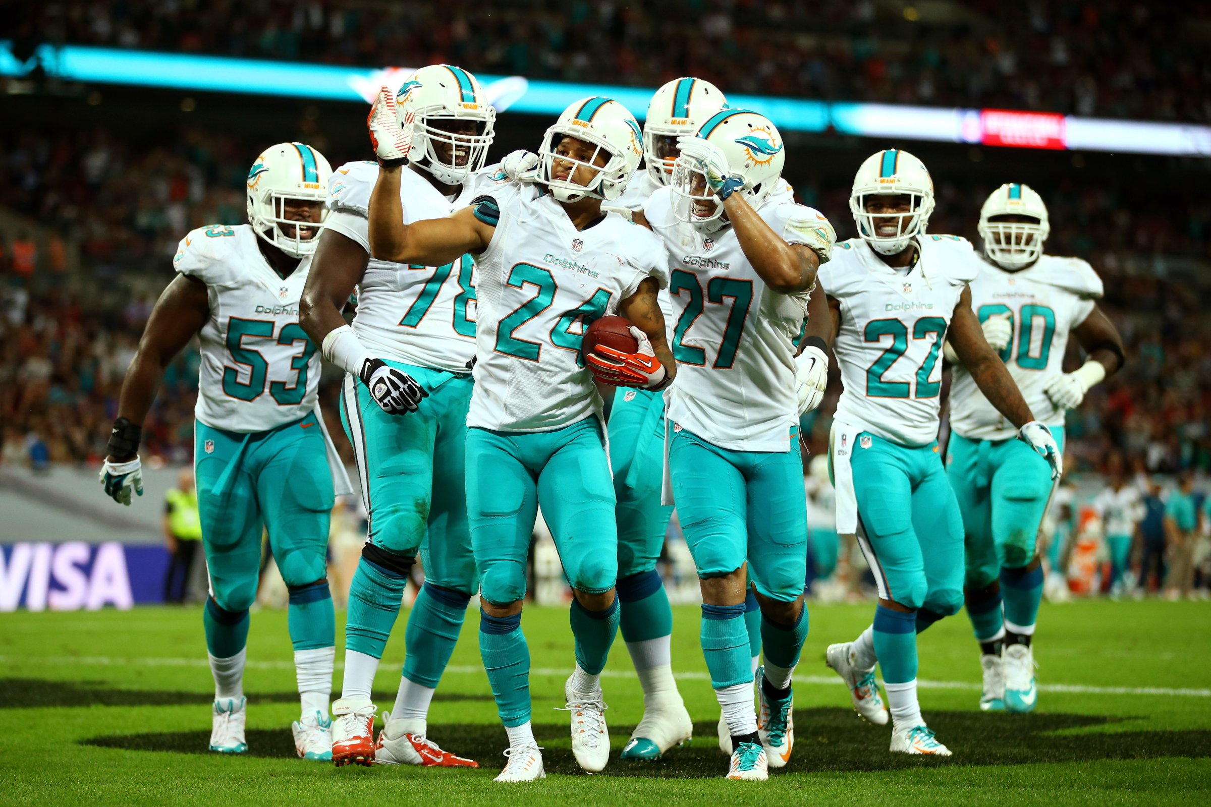 Cortland Finnegan of the Miami Dolphins celebrates with teammates after returning a fumble 50 yards to score a touchdown during the NFL match between the Oakland Raiders and the Miami Dolphins at Wembley Stadium on Sept. 28, 2014 in London,