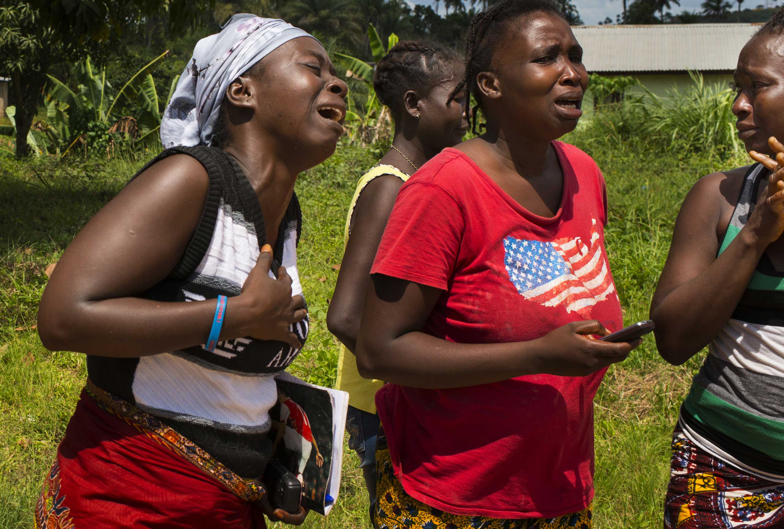 Relatives mourn after the body of Jacqueline Morris is taken away by a Lofa County health department burial team Nov. 7, 2014 in Voinjama, Liberia.