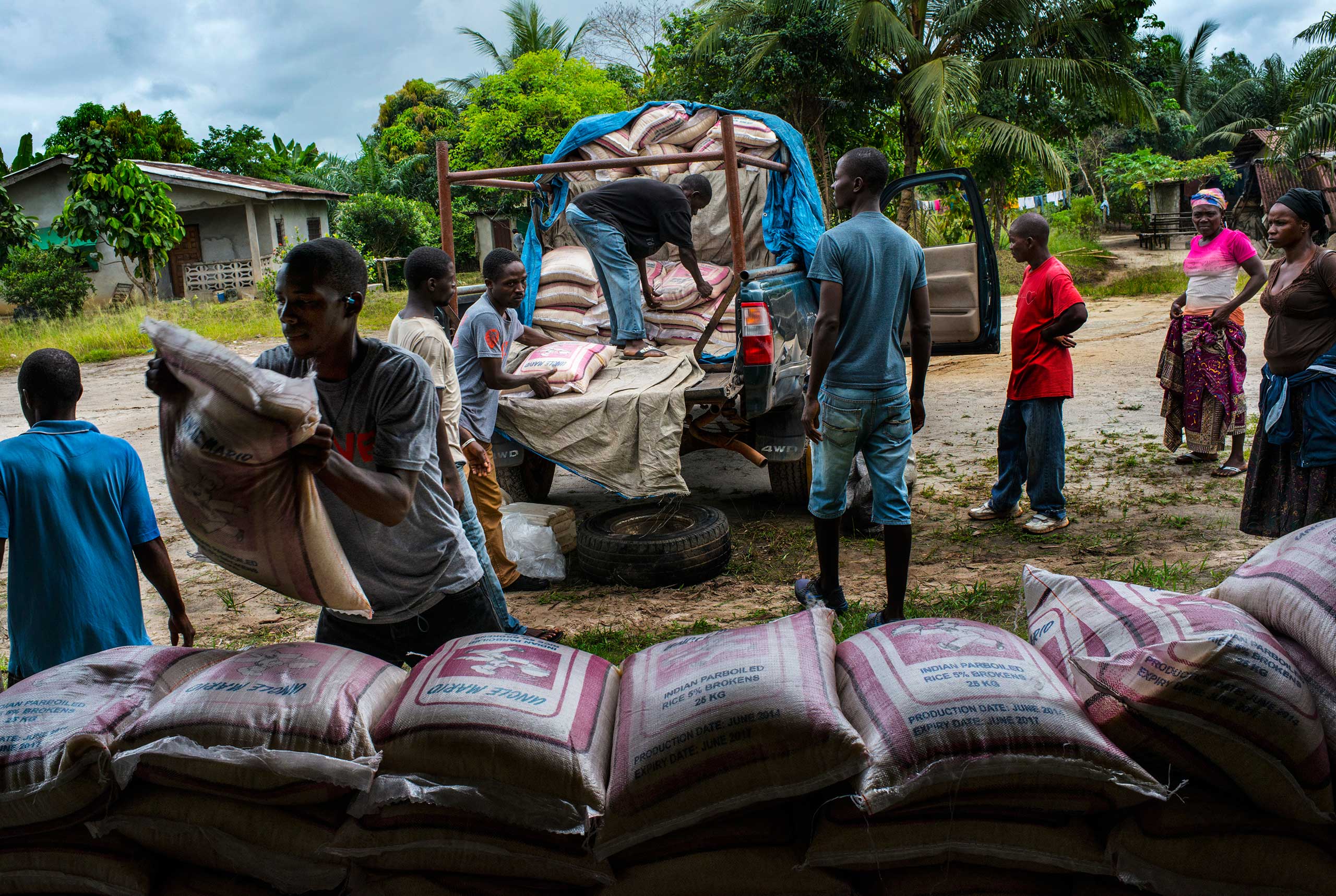 Staff from Orphan Aid, Liberia unload a truck of food and supplies for families affected by Ebola on Nov. 5, 2014 in Dolo's Town, Liberia.