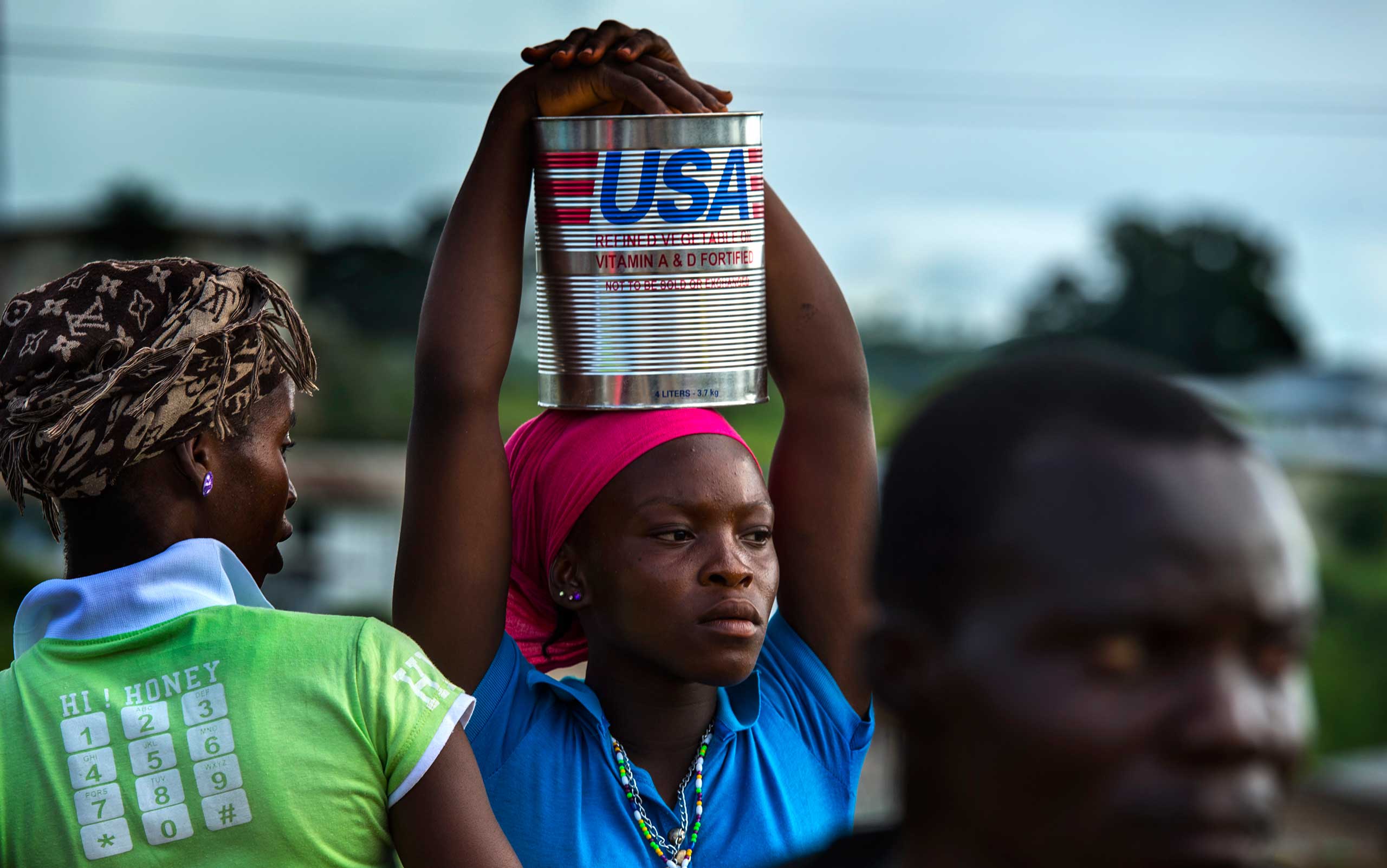 Mbolowilee Kollie, 17, waits with a can of cooking oil after her family received their share of food items from WFP's food distribution on Nov. 6, 2014 in Kolba City, Liberia.