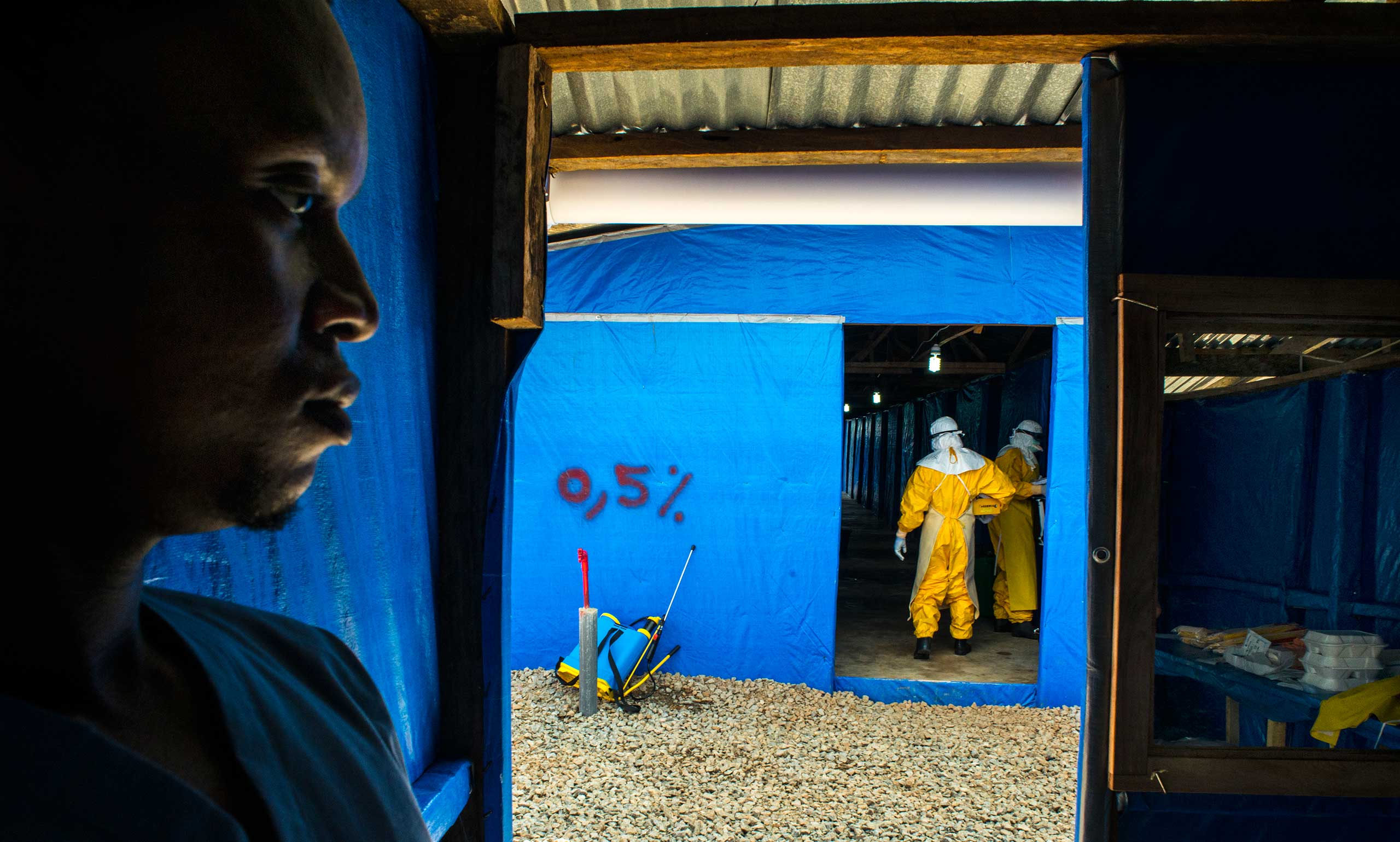 Moses Tarkulah stands by as colleagues enter the suspected Eloba case ward Bong County Ebola Treatment Unit, Sept. 16, 2014.