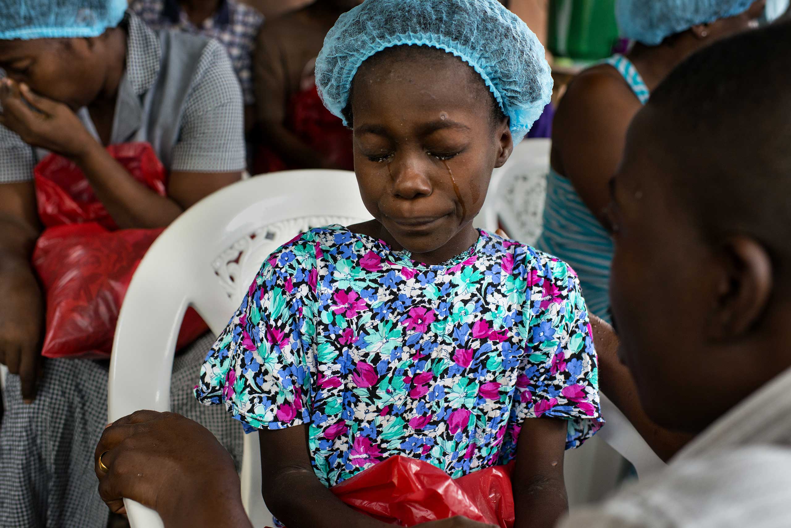 The following photographs are from Michel du Cille's assignment in Liberia, Sept.-Nov. 2014 Esther Tokpah, 11 an orphan, weeps as Dr. Jerry Brown tries to console her before she was released from care on Sept. 24, 2014 in Monrovia, Liberia.