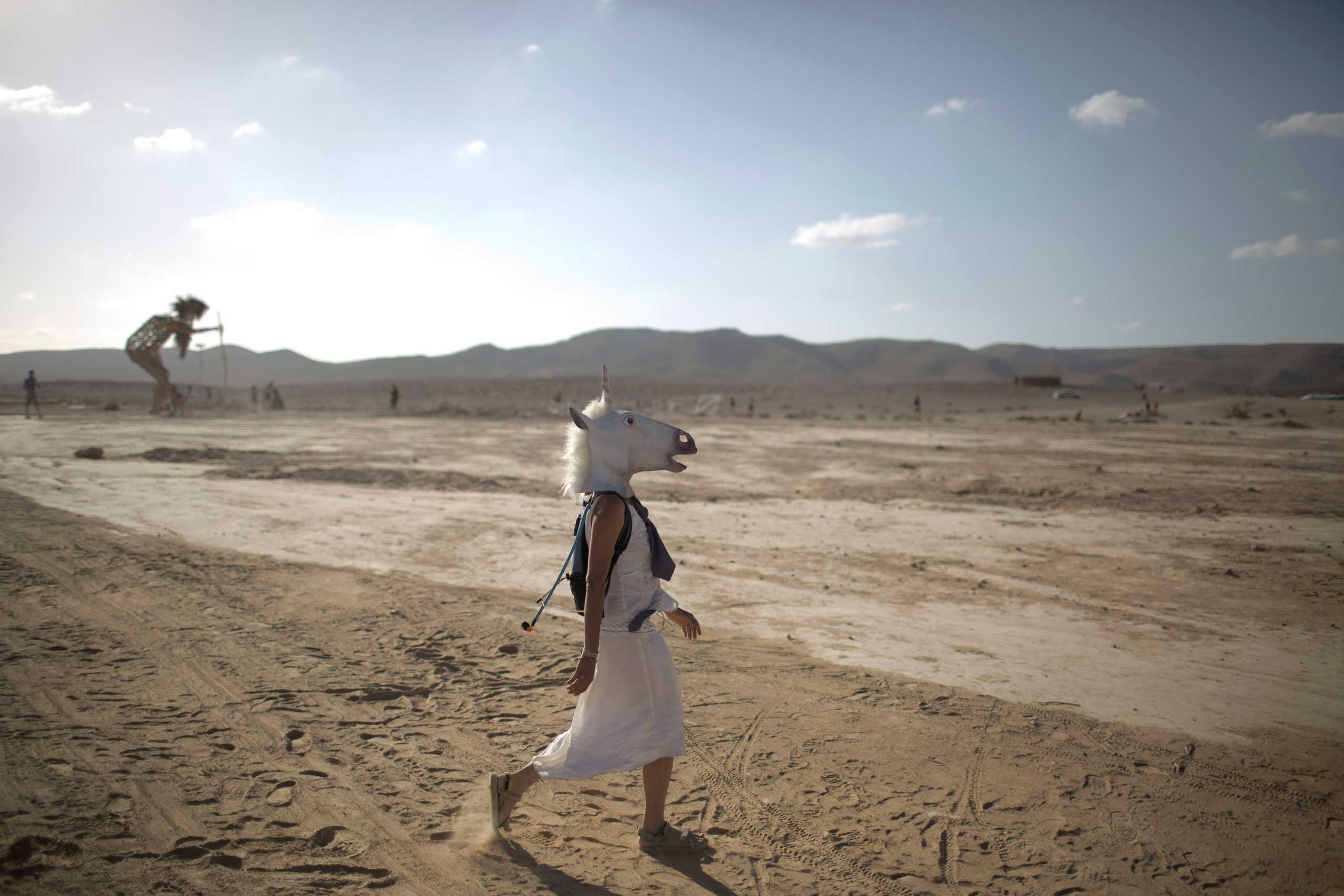 An Israeli woman wears a unicorn mask during the first Midburn festival, modeled after the popular Burning Man festival, near the Israeli kibbutz of Sde Boker, June 6, 2014.